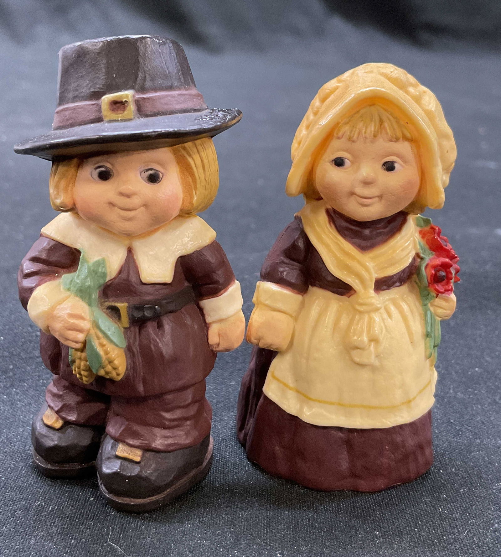 Set2 Vtg Hallmark Cards Pilgrim Boy&Girl Figurines: Set 2 vintage Hallmark Cards, Inc. pilgrim boy & girl figurines. Material appears to be plastic. Pilgrim boy and girl holding red flowers and corn, standing figurines. Measures 2.5 x 1.25 inches. Some