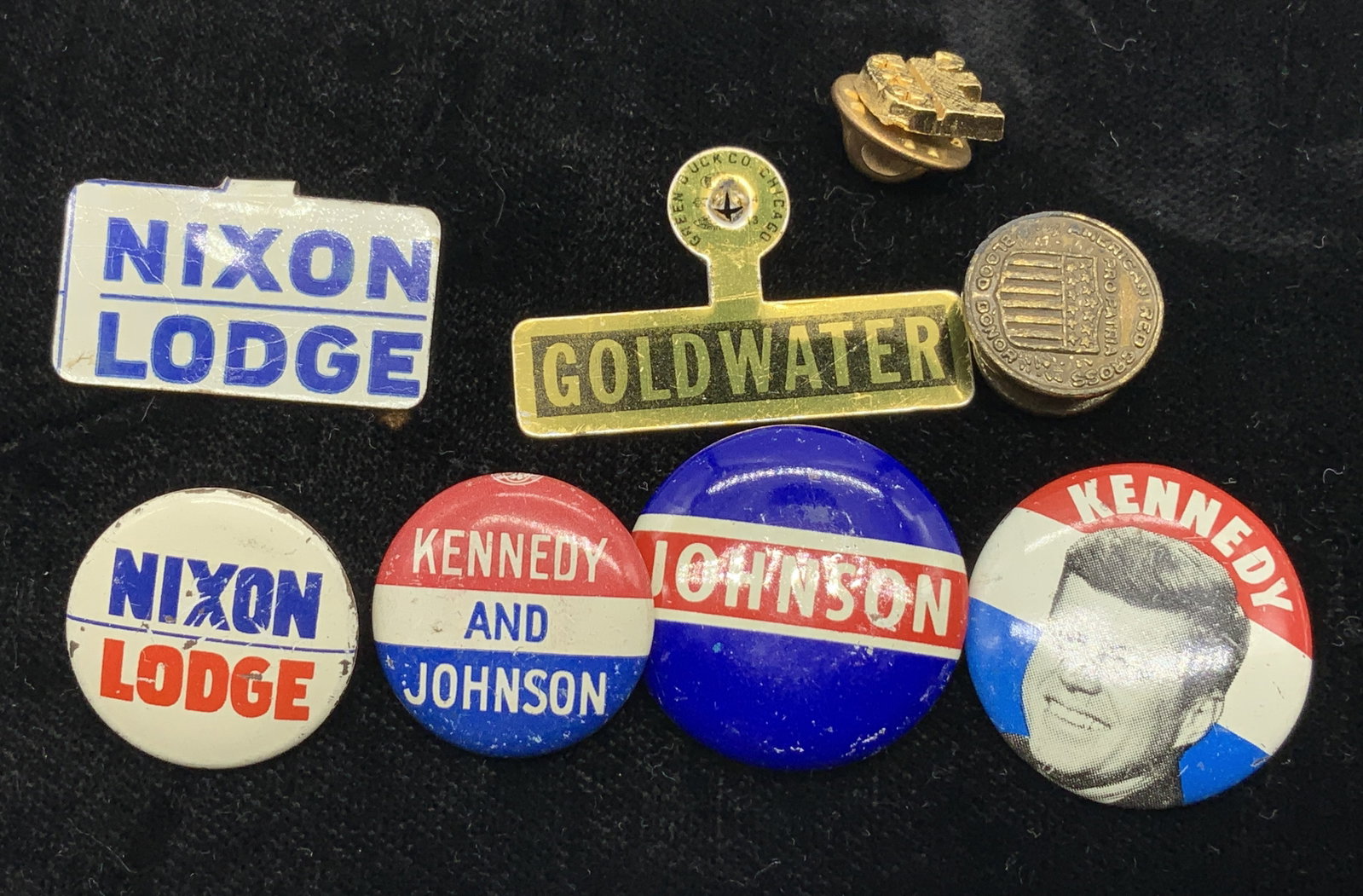 Lot 9 President Political Campaign Buttons & Pins: Lot includes 9 political campaign button & pins from American presidential elections. Buttons & pins read, America Needs Kennedy-Johnson, Nixon Lodge, Johnson, & Goldwater. Pins feature images of Kenn