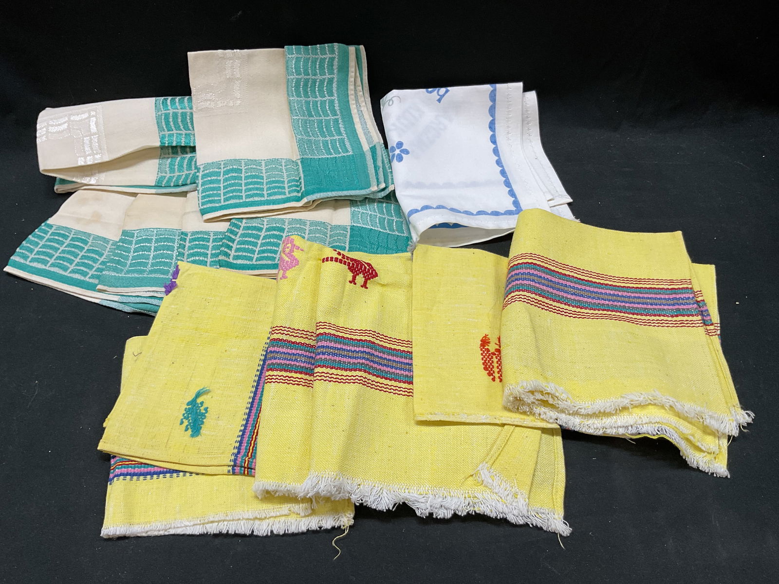 Lot 13 Colorful Table Linen Napkins Handkerchiefs: Lot 13 colorful table linen napkins and handkerchiefs. Lot includes 6 teal geometric design napkins, 1 KARCZMA POD KLUKA napkin, 6 yellow embroidered napkins. Largest napkin measures 13 inches. Some s