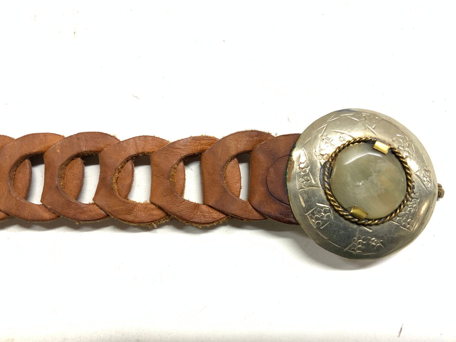 Braided Leather Belt W Silver Tn Etched Buckle: Belt is light brown toned and leather. Structure is braided. Piece has silver toned etched metal buckle with slate green toned faux stone in center. Belt is vintage. Measures approximately 43 inches l