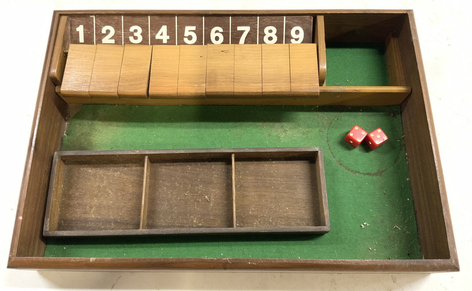 Vtg Shut The Box Game Wooden Partial Set: Appears to be Shut The Box game box. Box is brown toned and wooden. Piece has 2 red toned die. Wooden flaps to uncover numbers 1 through 9. Some areas lined in green toned felt. Measures approximately