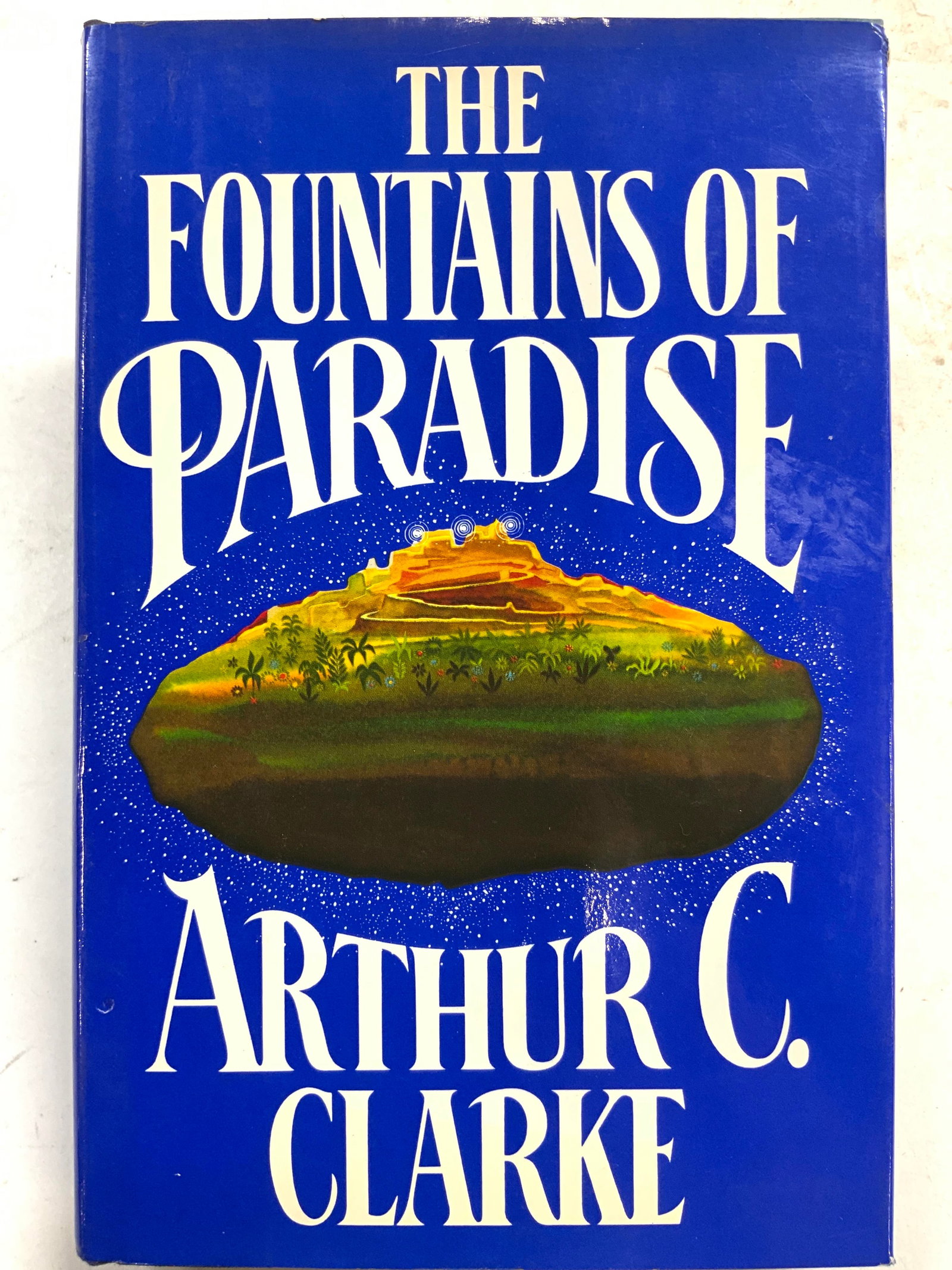 1978 The Fountains Of Paradise CLARK 1st Ed Book: Cover reads THE FOUNTAINS OF PARADISE. ARTHUR C CLARK. Book is vintage published in 1978 Harcourt Brace Jovanovich. Book is a first edition. Hard cover book with blue toned sleeve. Cover depicts a lan