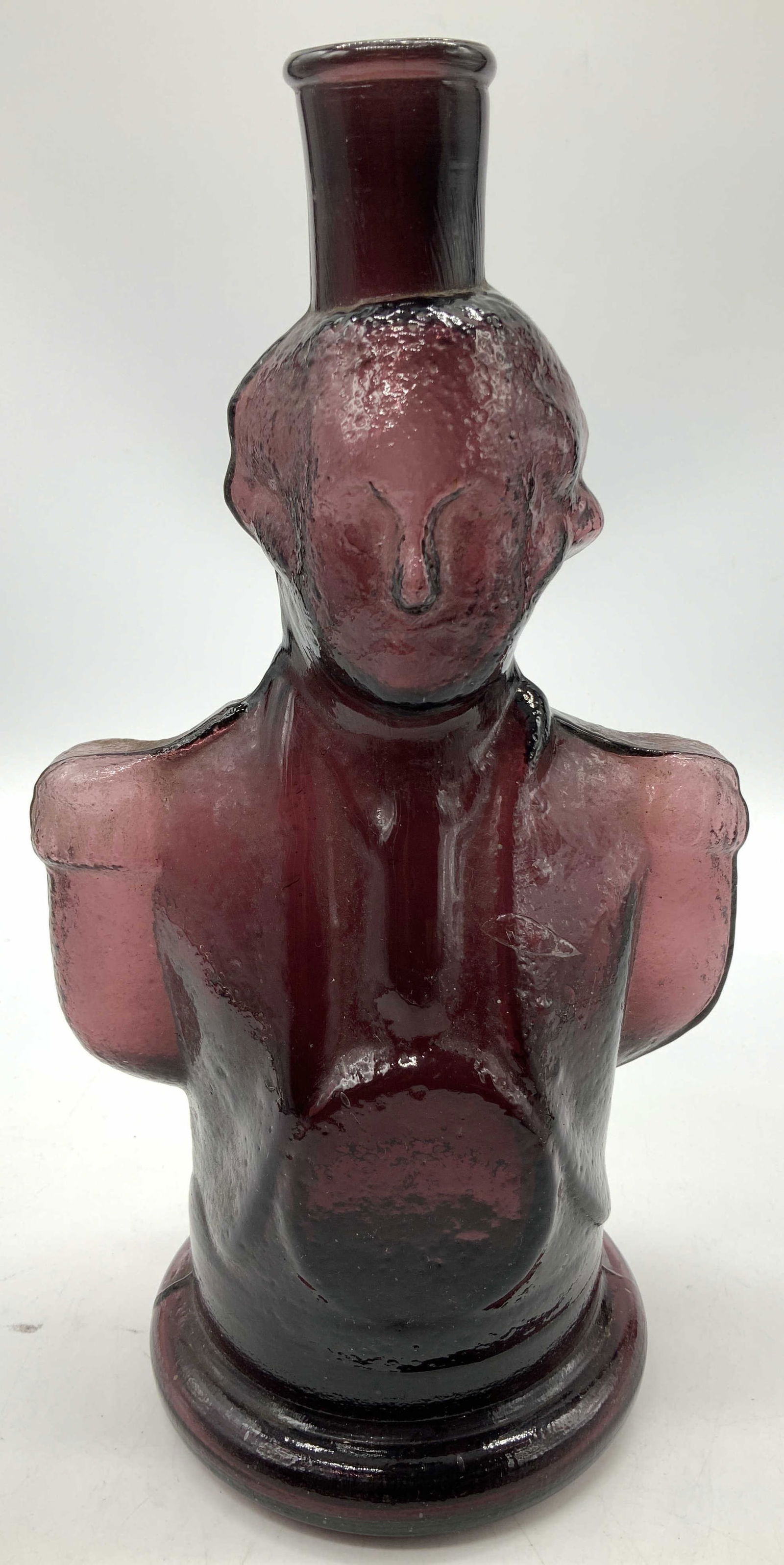 Vntg George Washington Bust Amethyst Glass Bottle: Vntg George Washington Bust Amethyst Glass Bottle Glass bottle shaped like a bust of General George Washington. Bottle is hand blown glass & features a deep amethyst color. Surface wear consistent to