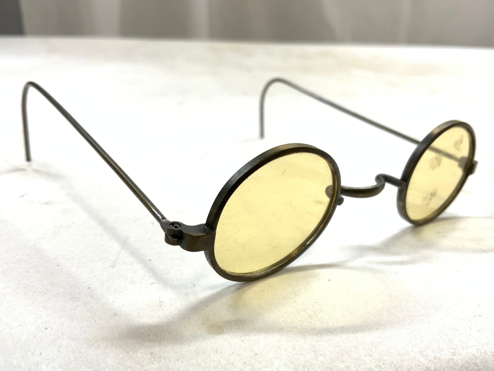Antq Round Metal Frame Childs Spectacles: Spectacles are antique. Piece has silver toned metal frames. Spectacles have ellipse form lenses. Each lens has yellow tint. Spectacles are child sized. Measures approximately 4 inches wide and deep 1