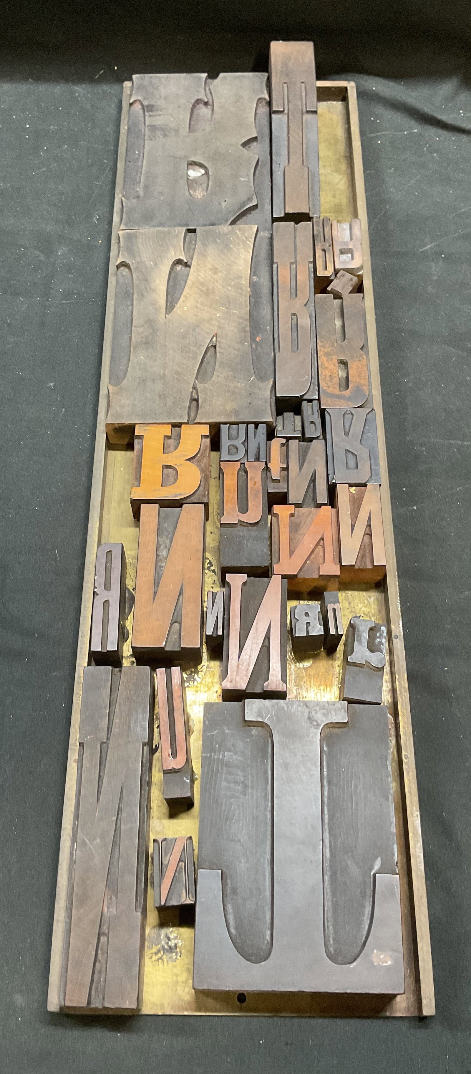 31 Vintage Brass Printing Plate & Wood Blocks: Vintage brass printing plate with vintage wood printing blocks. 30 printing blocks. Capital and lowercase letters N, T, and R. Various fonts and sizes. Largest block approx 6 x 4 inches. Plate measure