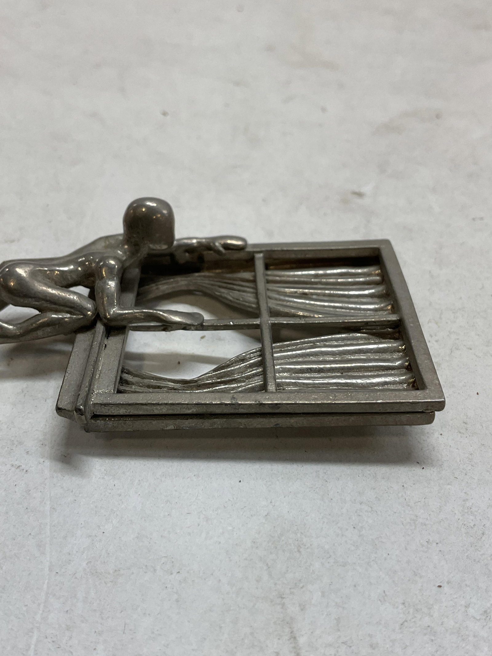 Vtg 1980s IRAFA Laeri Nast Silver Tn Metal Pin: Vintage 1980s IRAFA Laeri Nast silver tone metal pin. Artistic nude pin of figurine climbing on window frame design in modernist style. Measures 3.25 x 1.5 inches. Some surface wear consistent with ex