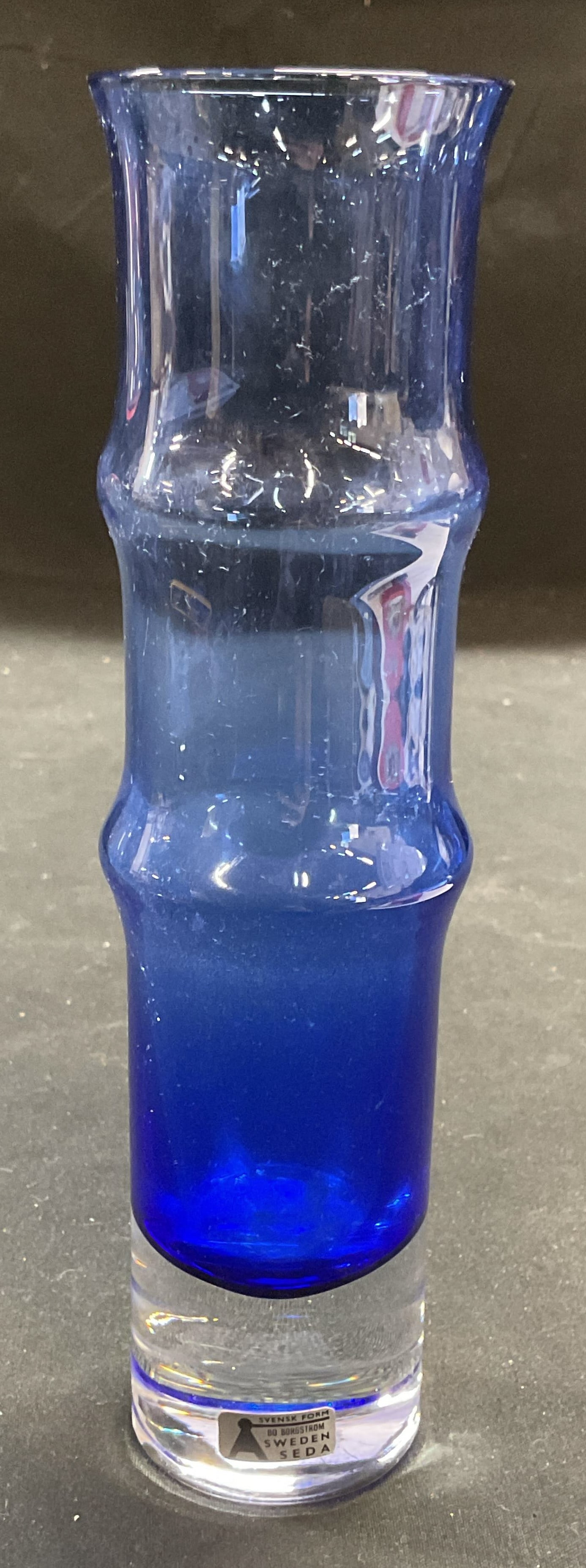 MCM Bo Borgstrom Art Glass Vase, Sweden: Mid century modern vintage Bo Borgstrom art glass vase. Bamboo form gradient cobalt glass with clear base. Signed on label. Measures approx 2 x 7.5 inches. Some surface scratching to base observed. Bo