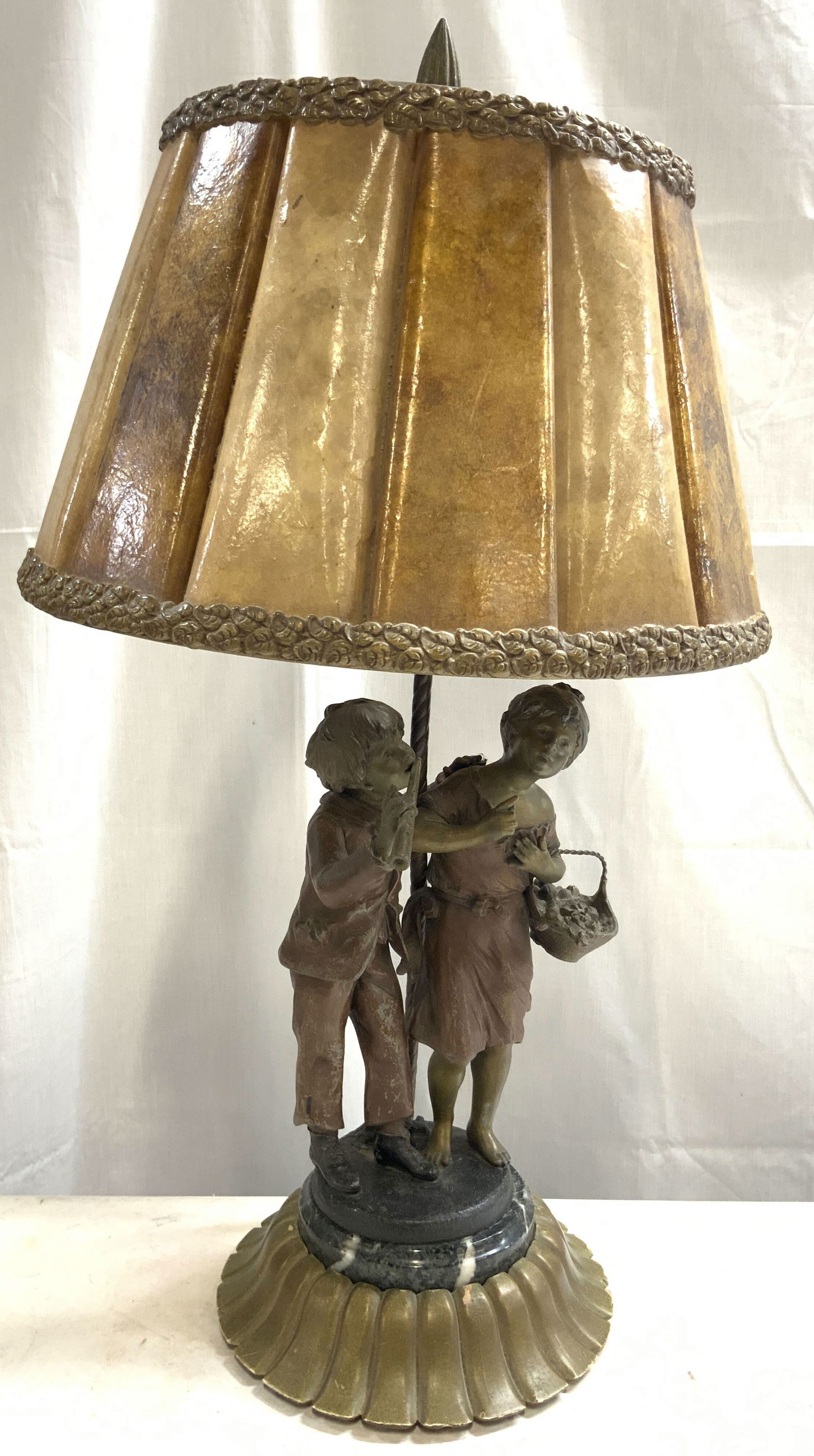 Vtg Metal & Marble Figural Tbl Lamp, Pleated Shade: Lamp is vintage. Piece has one boy and one girl figure each gilt metal. Girl depicted holding a basket boy depicted playing an instrument. Piece has scalloped wooden base with marble in center. Shade