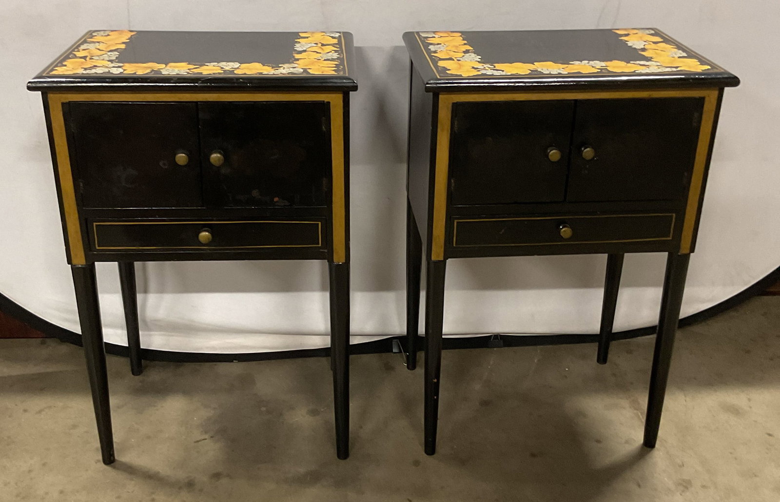 Pair Antique Black Gilt Grapevine Wood Nightstands: Pair of antique wood nightstands. Hand painted. Black with painted gilt grapevine motif on tabletops and gilt painted line borders on cabinet and drawers. Measure approx 18.5 x 13.5 x 27.5 inches. Sur