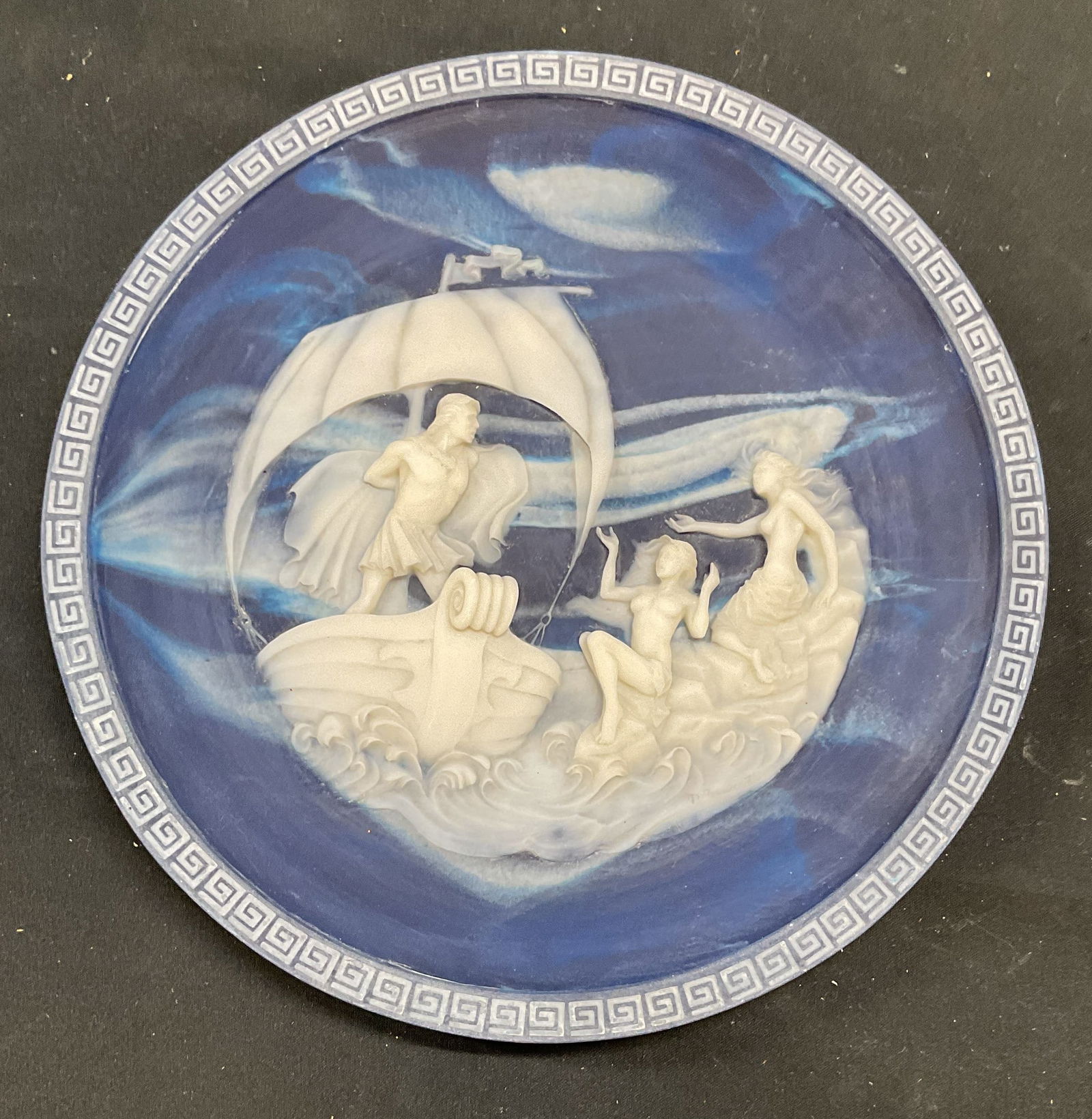 Ulysses The Sirens Incolay Stone Cameo Plate USA: Limited edition Incolay Studios plate, marbled lapis blue cameo stone. The Sirens from The Voyage of Ulysses series. Carved Greek key border. Limited edition, numbered on underside. Made in USA. Desig