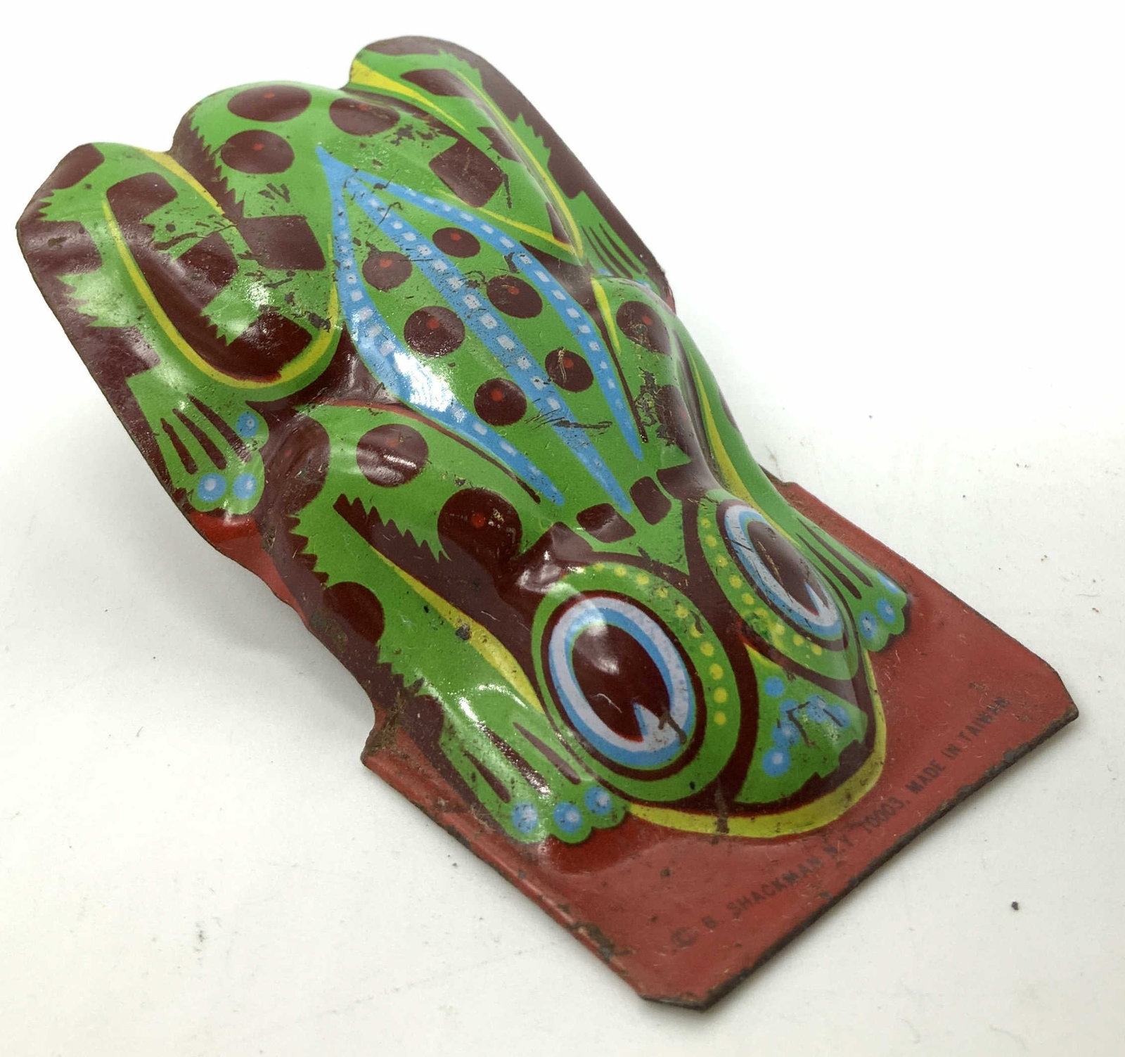 Vntg SHACKMAN Tin Green Frog Clicker Toy: Vntg SHACKMAN Tin Green Frog Clicker Toy Clicker toy depicting a green frog with dark red spots. Toy appears to be tin material. Signed & marked. Reads, B. SHACKMAN NY. MADE IN TAIWAN. Surface wear co