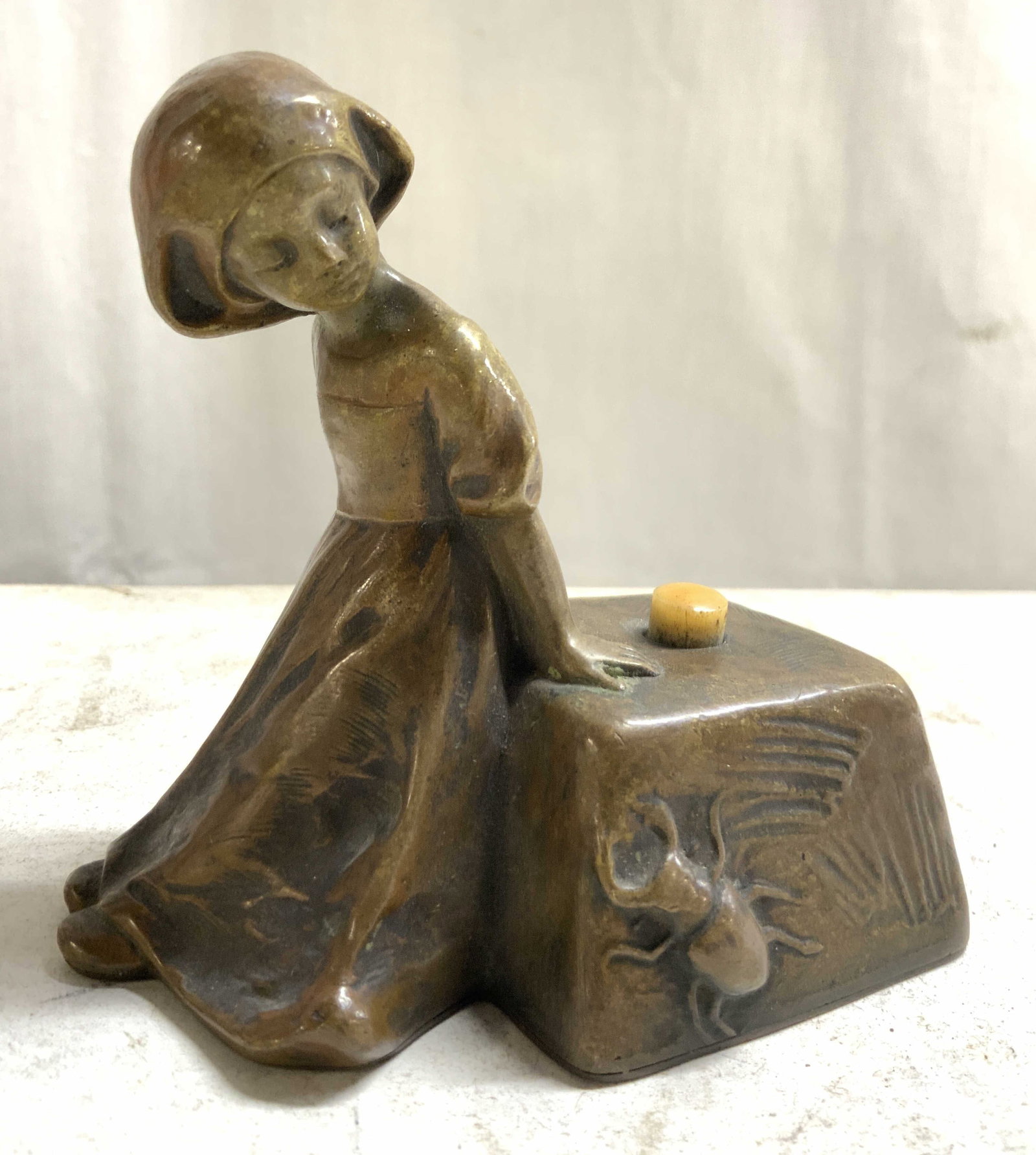 BELLS BY TERESZCZUK Vtg G Metal Girl Fig Bell: Backside is signed TERESZCZUK. Bell is gilt metal, appears to be brass. Piece depicts a female child figure leaning on an object with a beetle on the front. Piece appears to be vintage possibly antiqu