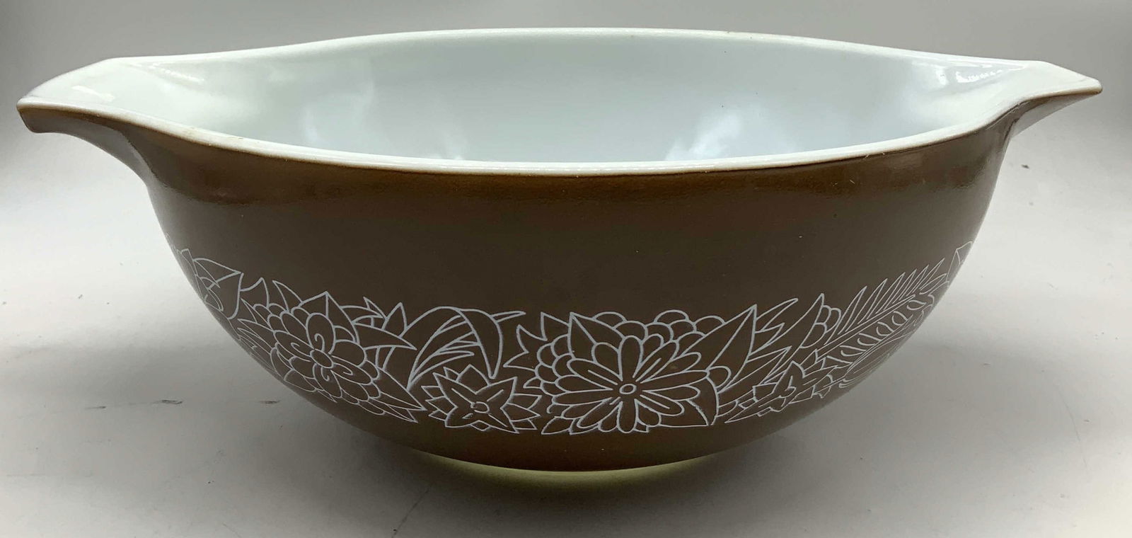 PYREX Brown Woodland Milk Glass Casserole Dish: Casserole dish features a dark brown/chocolate color & white outlines of flowers & leaves. Dish appears to be milk glass material. Signed & marked on underside. Reads, PYREX. Surface wear consistent t