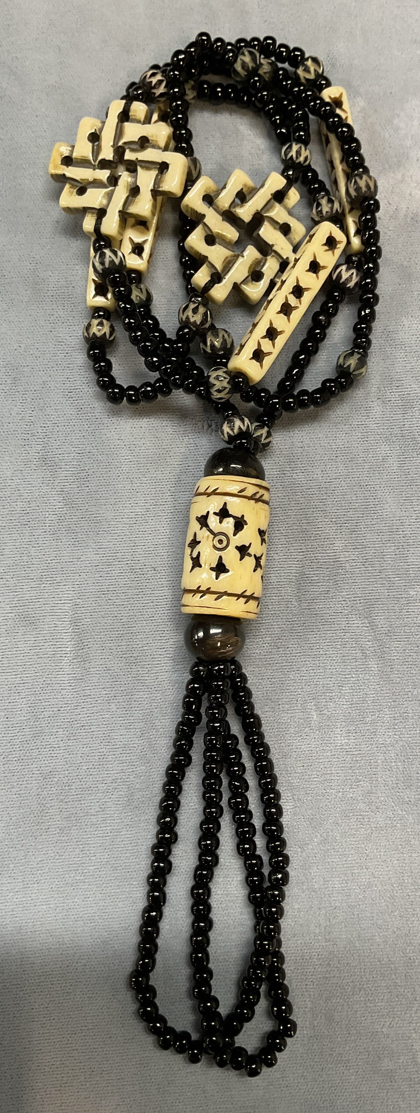 Vintage Black Beaded Bone Pendant Necklace: Vintage black beaded necklace with carved white pendants. Appears to be bone. Drop length approx 15 inches. Some scratching observed. Jewelry, estate jewelry, costume jewelry, cocktail jewelry, fashio