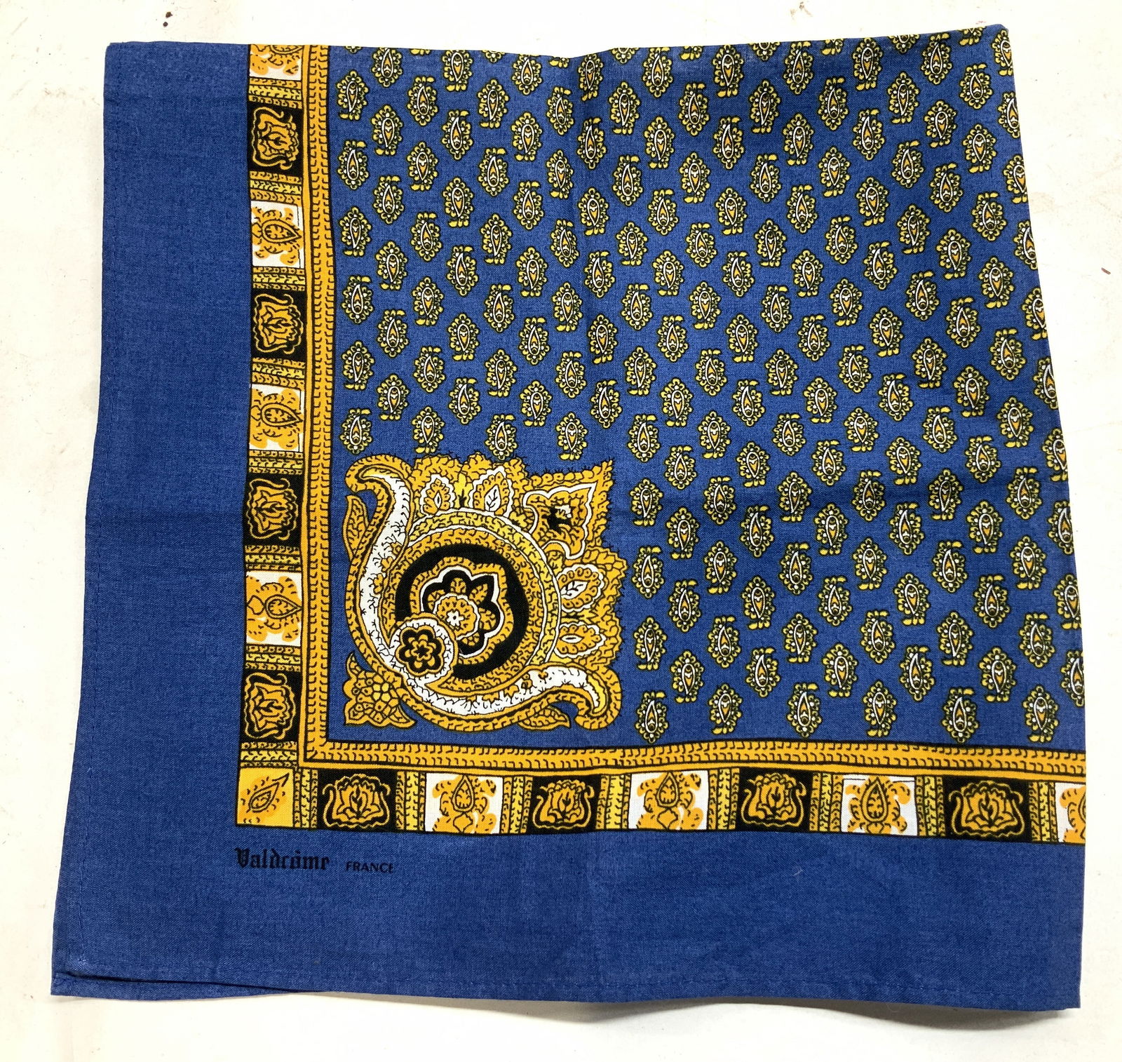 Vntg Valdrome Blue & Gold Paisley Scarf FRANCE: Vntg Valdrome Blue & Gold Paisley Scarf FRANCE Scarf featuring an intricate gold paisley & geometric pattern on a blue background. Scarf appears to be possible cotton/polyester. Signed & marked. Reads