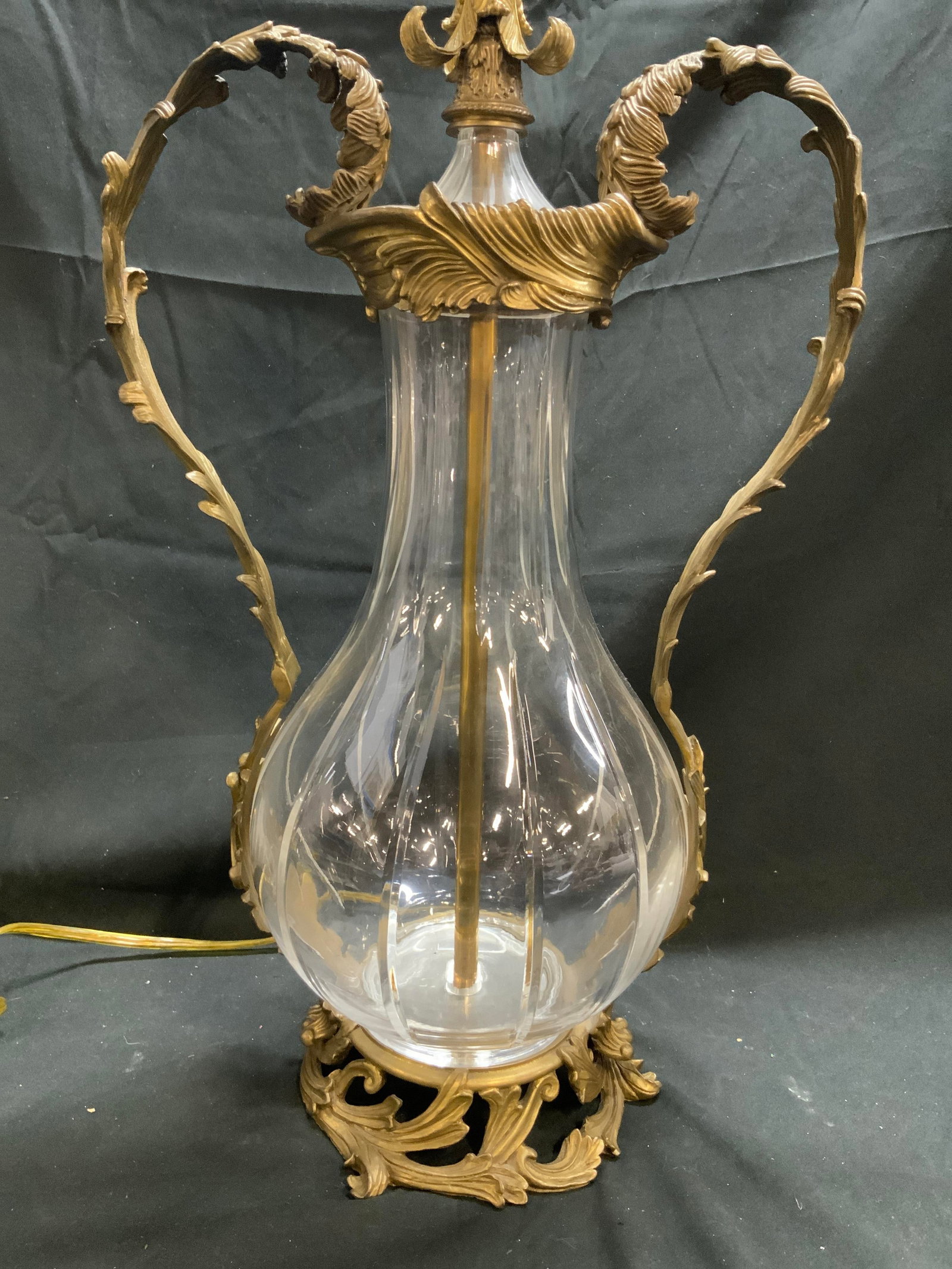 JOHN RICHARD Vtg Glass & Brass Tbl Lamp: Lamp appears to be JOHN RICHARD (No apparent markings). Lamp is glass and brass. Piece has ornate scroll and leaf structures. Lamp has half heart curl leaf handles. Lamp includes harp and curled leave