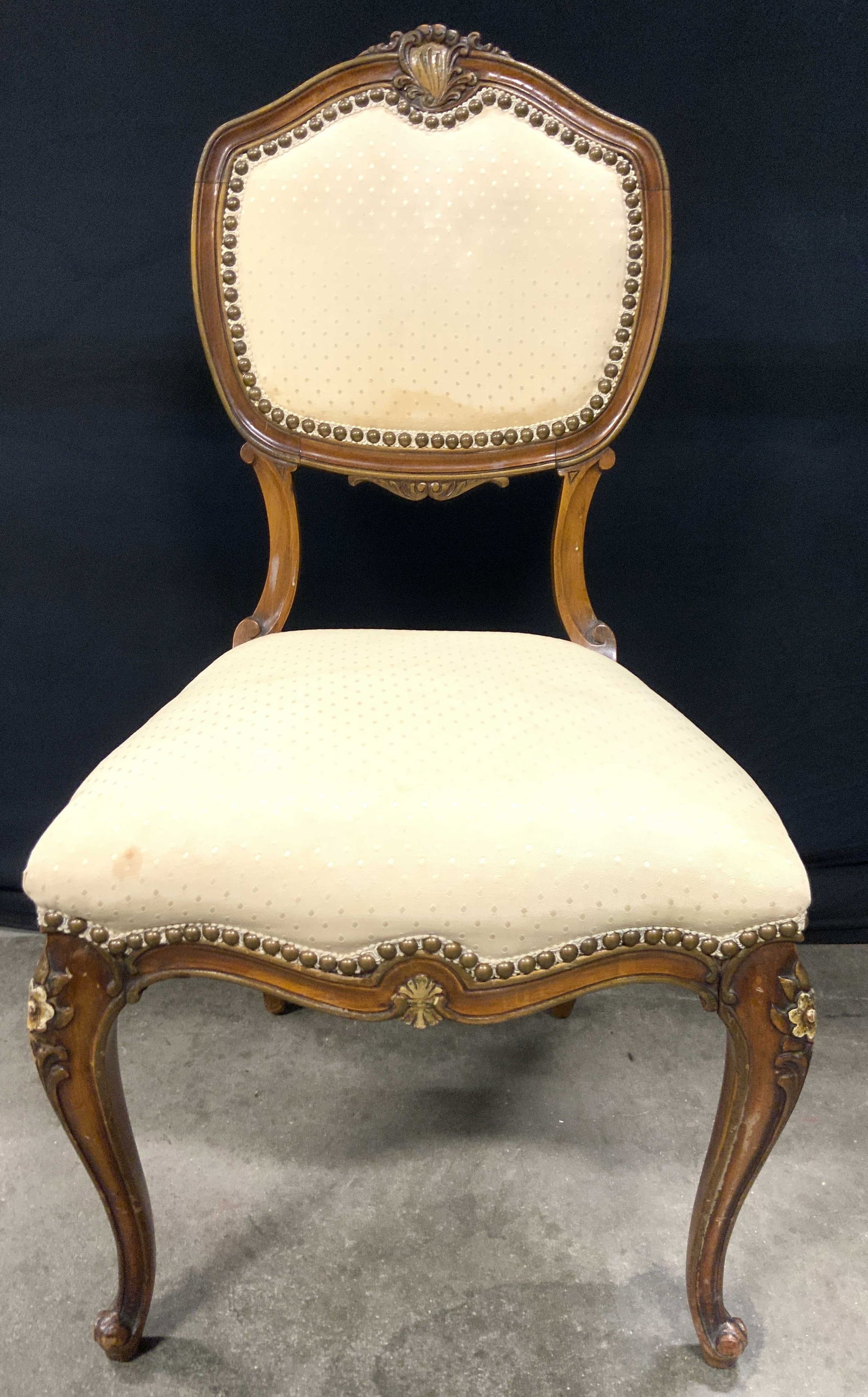 Vtg Louis Xv Wooden Uph Side Chair: Side chair is Louis Xv style. Piece is vintage. Side chair has tan toned wooden frame, cream toned Polka dot upholstery, nailhead detail at edges and carved floral detail Chair measures approximately