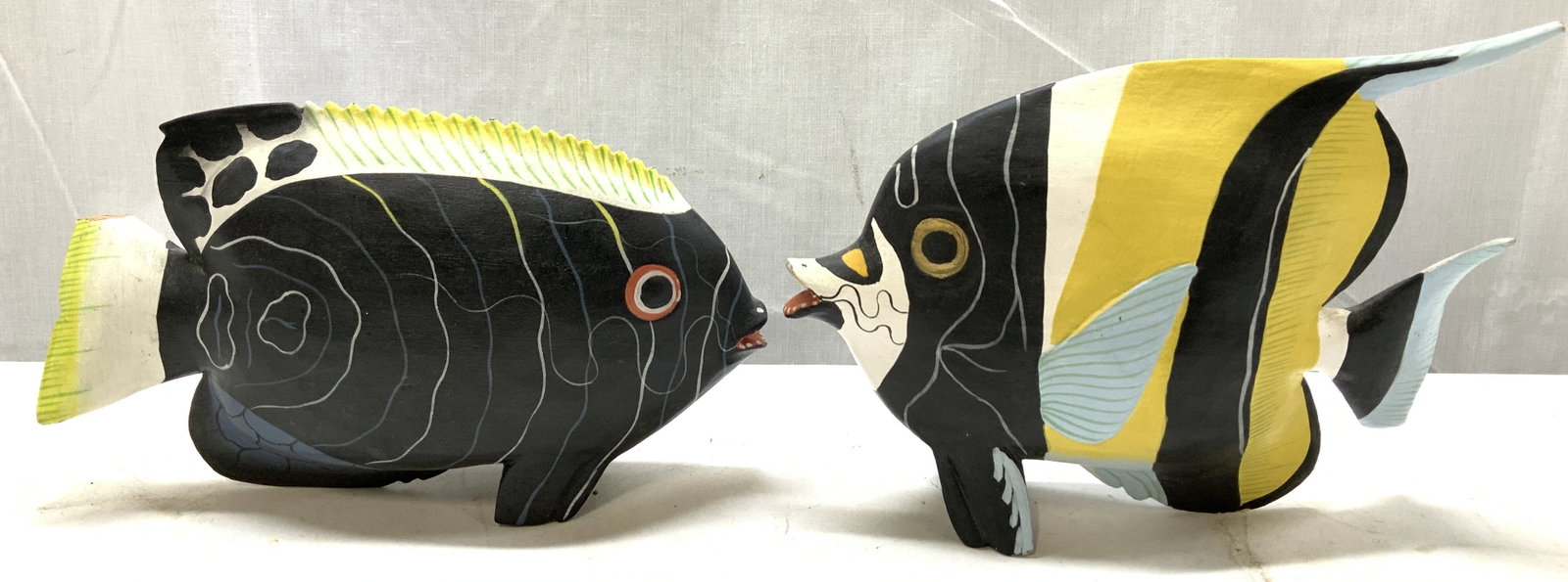 Lot 2 Hand Carved Wooden Tropical Fish Figs.: Lot 2 Hand Carved Wooden Tropical Fish Figurines Wooden figurines depicting 2 hand carved tropical fishes featuring a small protruding mouth. Marked on underside. Reads, MADE IN INDONESIA. Surface wea