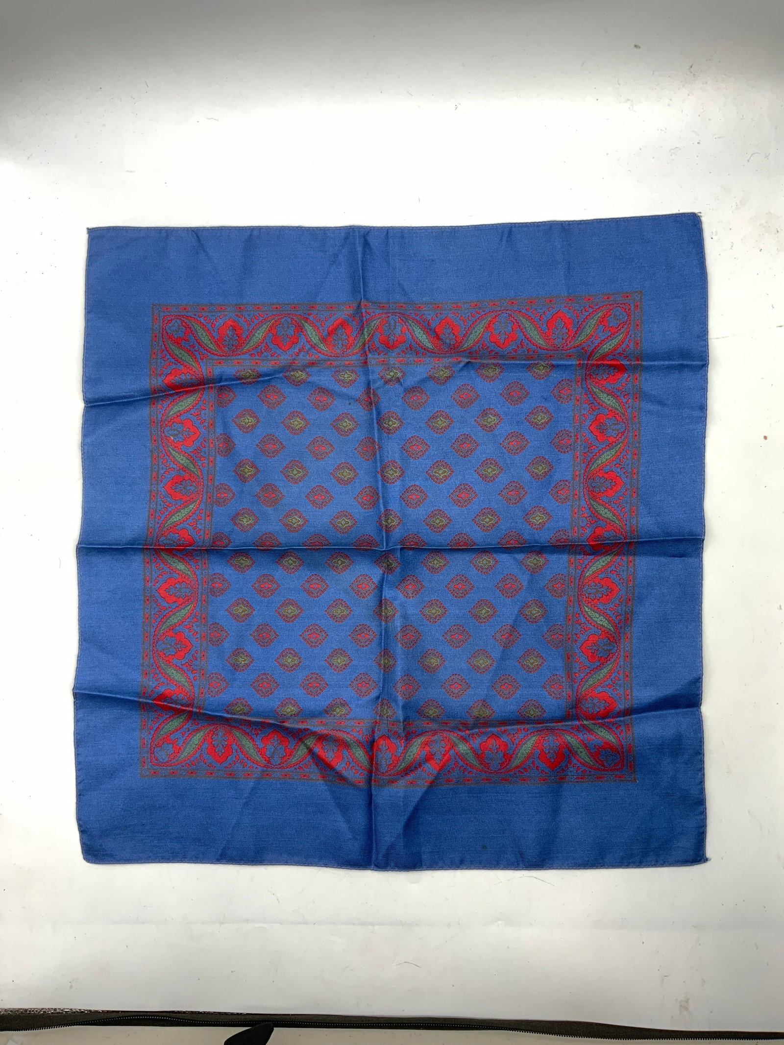 Vintage Blue Floral Bandanna Scarf: Vintage blue silken polyester floral bandanna scarf. Blue scarf with red and green floral patterns. No material tag attached, appears to be silken polyester. 17.5 inches. Some surface wear consistent