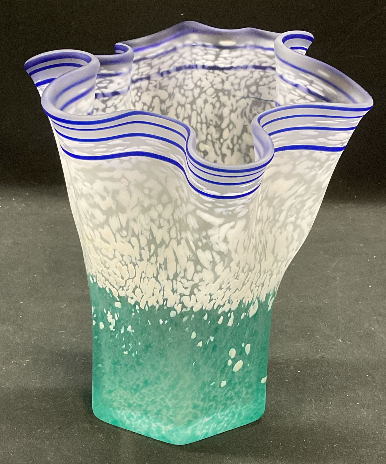Blue White Satin Art Glass Handkerchief Vase: Satin art glass vase with speckled blue and white and blue banded design. Handkerchief rim. Measures approx 6.5 x 7 inches. Some wear consistent with exposure. Art glass vase, satin glass vase, blue v