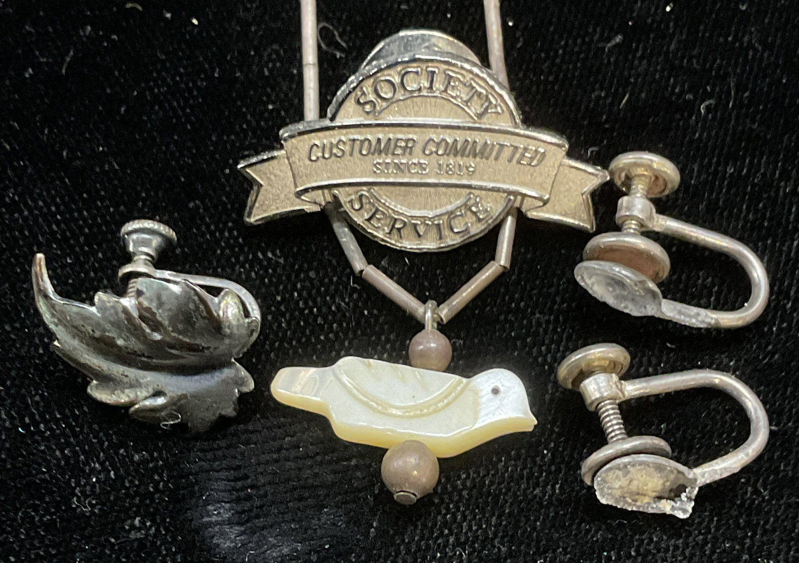 Lot 4 Sterling Silver, Pin, Earrings, Necklace: Lot of 4 sterling silver jewelry pieces. Mother of pearl bird pendant necklace, single leaf motif earring, society service pin, and pair of earring backings. Necklace drop length approx 7.5 inches. To