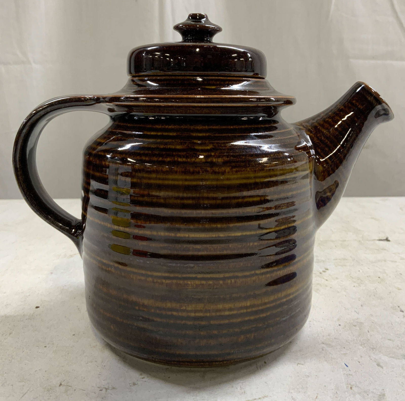 Vtg Arabia Finland Mahonki Tpot Ulla Procope 1960s: Underside marked ARABIA MADE IN FINLAND. Teapot is brown toned and ceramic. Designed by ULLA PROCOPE circa 1960s. Vessel includes lid. Piece has ribbed texture. Teapot is vintage. Measures approx 7 in