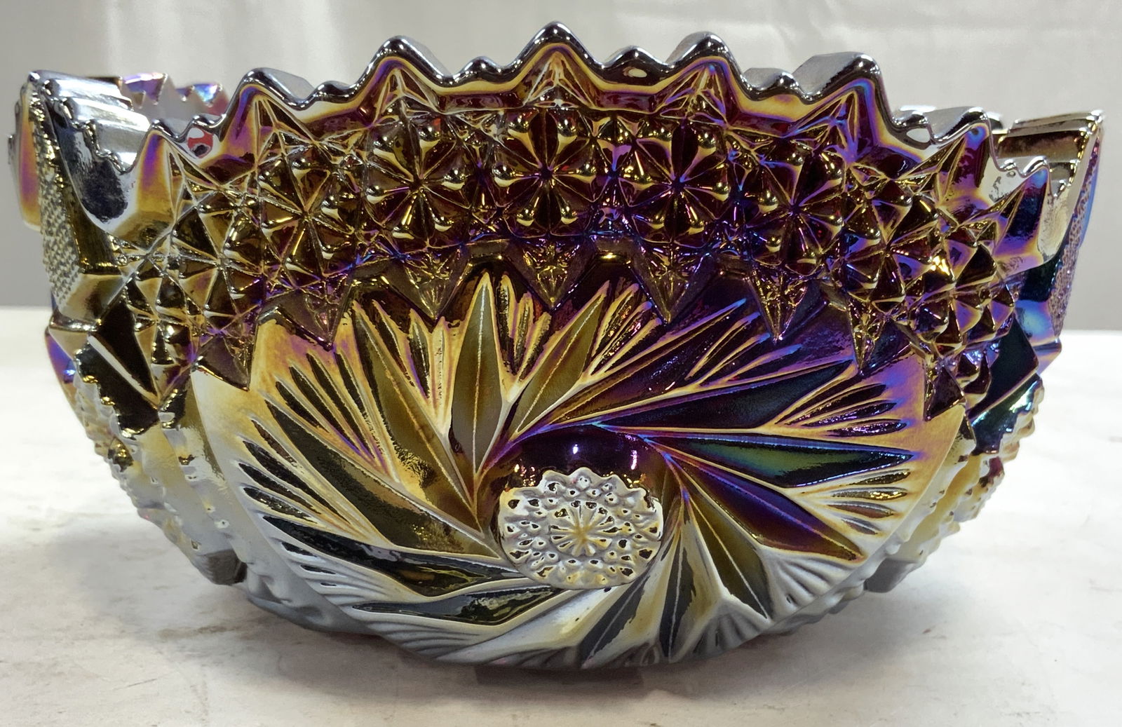 Vtg Amethyst Saw Tooth Rim Carnival Glass Bowl: Bowl is vintage. Amethyst iridescent luster carnival glass bowl with intricately cut geometric detail. Bowl has saw tooth form rim. Vessel measures approximately 7.5 inches wide 3.5 inches tall. Bowl,