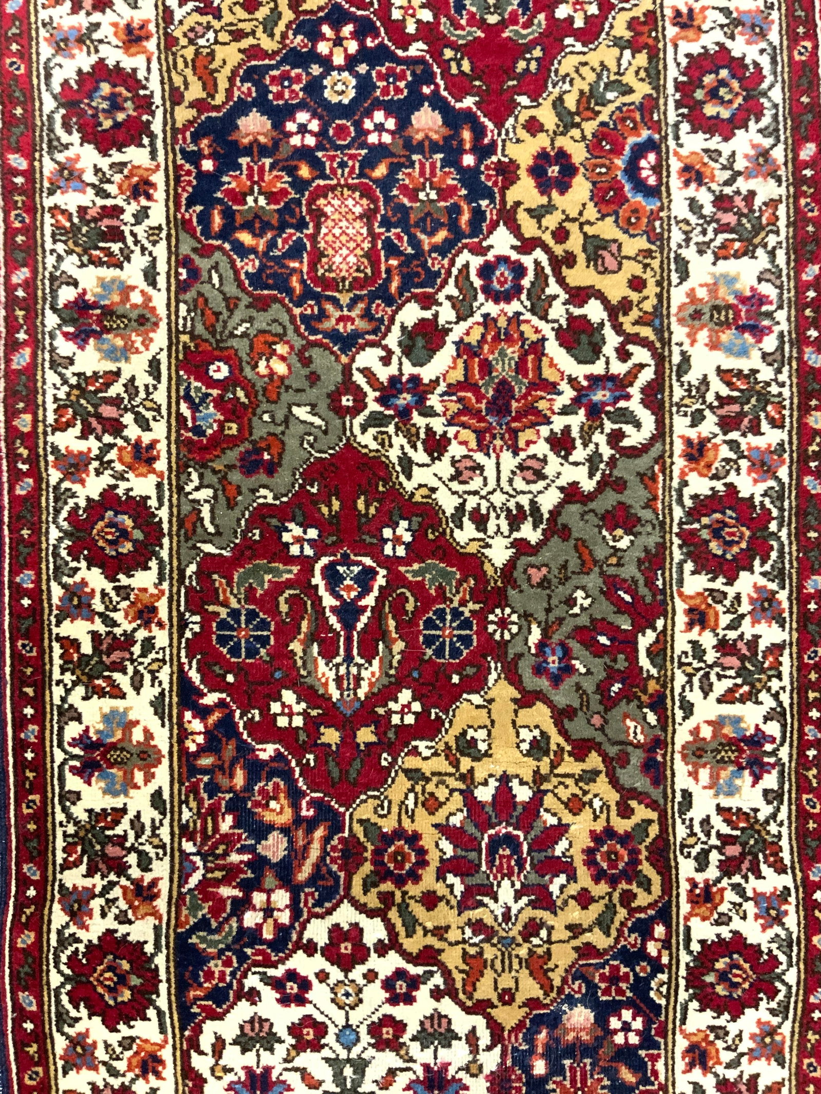 Vintage Handmade Persian Wool Runner: Runner is handmade and wool. Piece is vintage, appears to be Persian. Rug has intricate multi toned floral motif and patterned detail. Runner has cream toned fringes. Measures approximately 123 inches