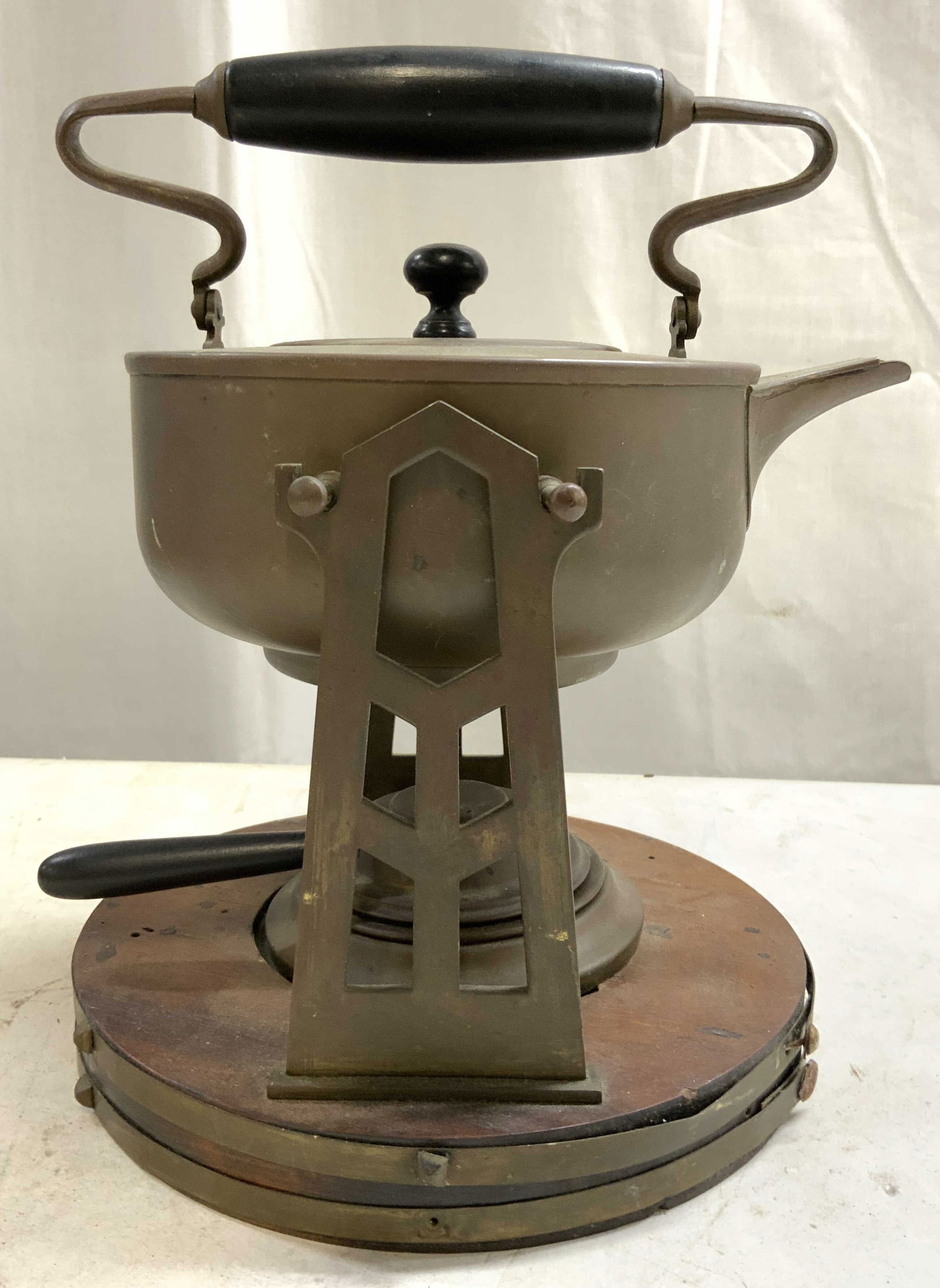 STERNAU & CO Atq Copper Spirit Kettle w Stand: Underside is inscribed STERNAU & CO. Spirit kettle is copper. Piece has wood and metal stand with circular form base. Kettle has Ebonized wood handle and lid. Piece measures approximately 10 inches ta