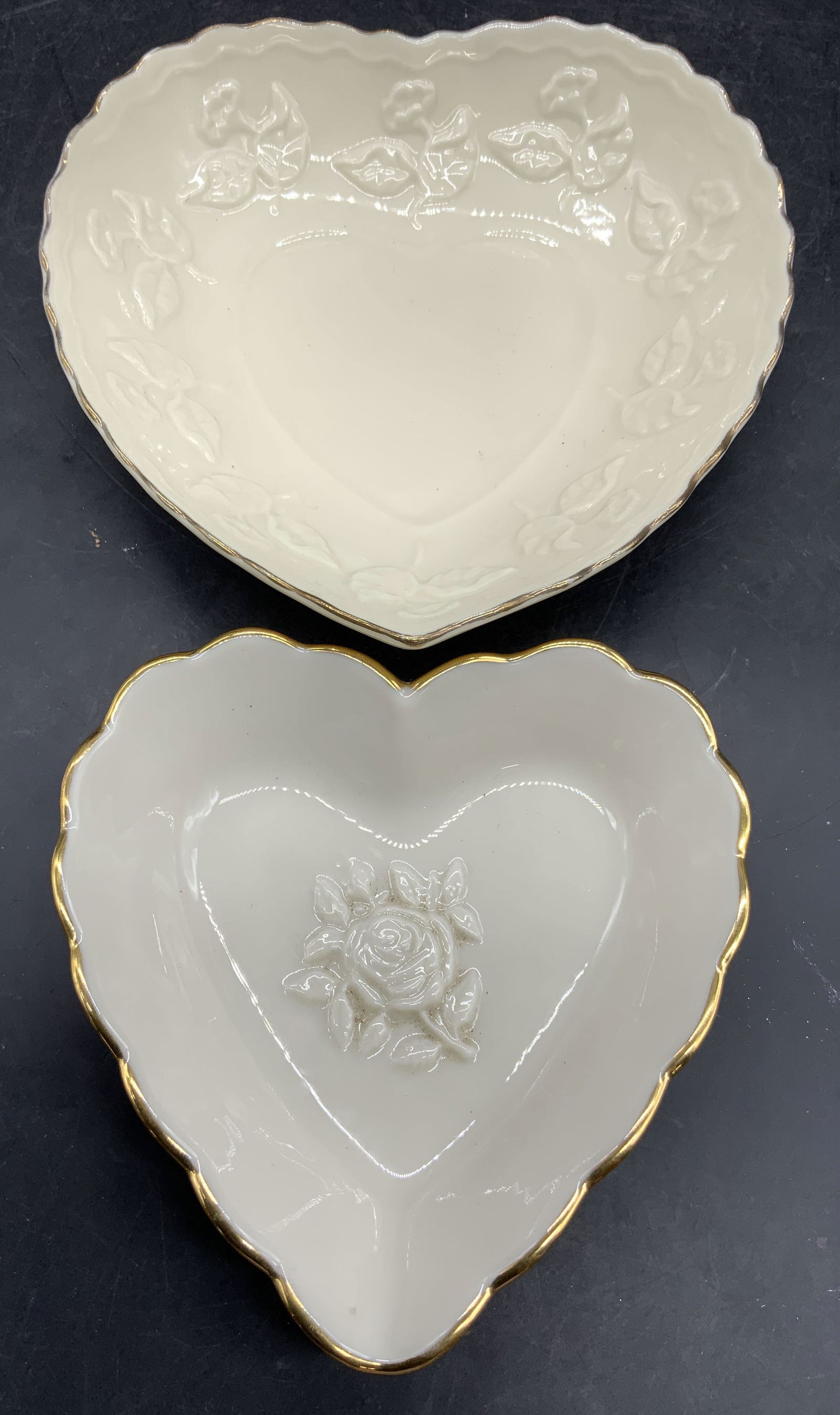 2 Porc Heart Dishes LENOX & SHIAN YIH ROC: Underside trademarked LENOX other trademarked SHIAN YIH ROC. Lot includes 2 heart form dishes. Each are cream toned and porcelain. Dishes have different beveled floral detail and gilt rims. Largest me