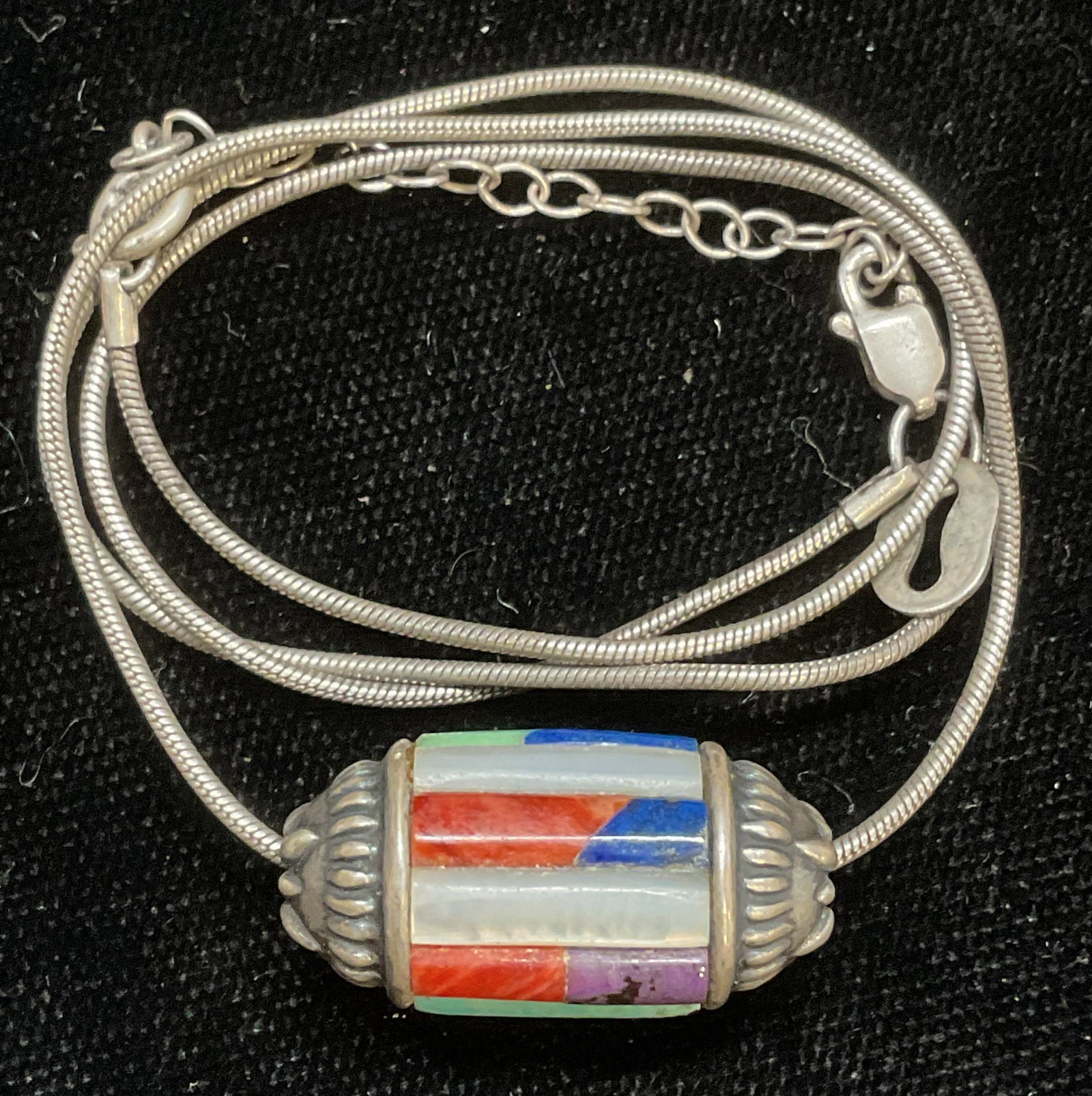 Signed Sterling Silver Semiprecious Necklace: Signed Sterling silver pendant necklace with inlaid semiprecious stone and mother of pearl pendant. Lapis, turquoise, mother of pearl. Signed illegibly. Marked sterling. Drop length approx 8.5 inches.