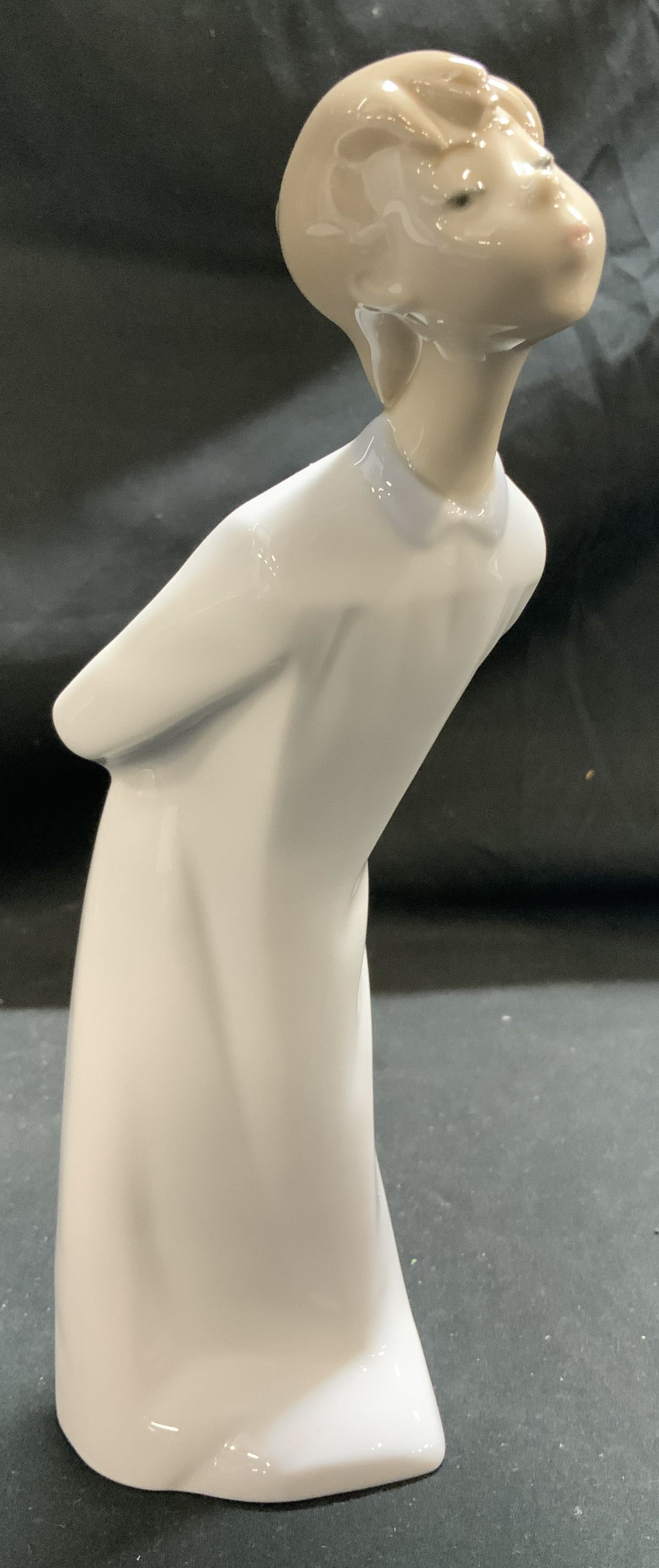 LLADRO Kissing Boy Porcelain Figurine SPAIN: Porcelain figure depicting a boy in a nightdress, blowing a kiss. Figurine features a glossy finish. Signed & marked on underside. Reads, LLADRO HAND MADE IN SPAIN. Surface wear consistent to age, use