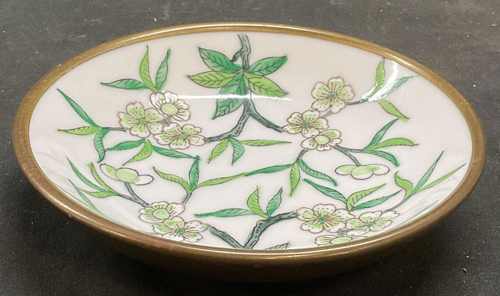 Signed Overjoy Vtg Porcelain Brass Floral Bowl HK: Signed vintage porcelain bowl with brass overlay. Marked on underside Overjoy hand painted in Hong Kong with sail boat hallmark. Hand painted, floral motif in green. Measures approx 5.5 x 1.25 inches.