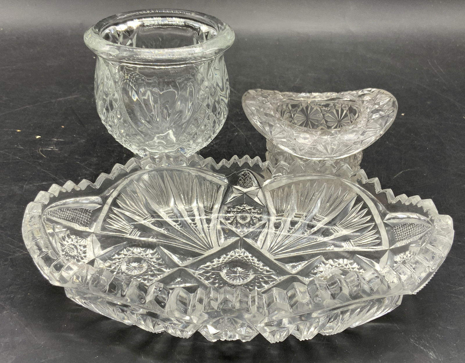 Lot 3 Art Glass & Crystal Tabletop Accessories: Lot includes 1 art glass hat vessel, 1 footed art glass candle holder with goblet form, & 1 cut crystal oval form bowl with saw tooth rim. Each piece has intricate geometric relief detail. Saw tooth b