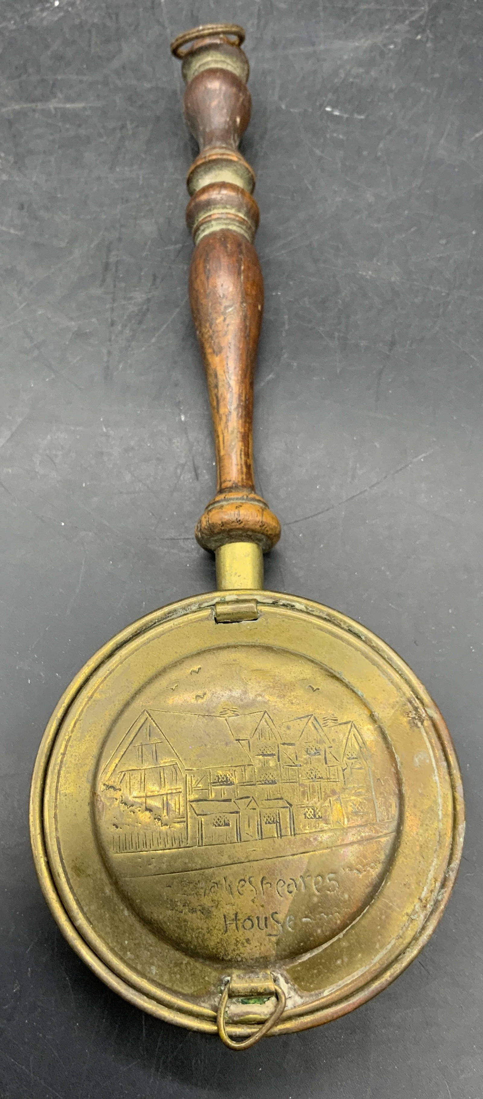 SHAKESPEARES HOUSE Atg Brs & Wood Crumb Catcher: Silent butler Crumb catcher is antique. Piece reads SHAKESPEARES HOUSE. Piece is brass & wooden. Lid has etched detail of house. Piece has Loop at end of handle to hang. Measures approximately 9 inche