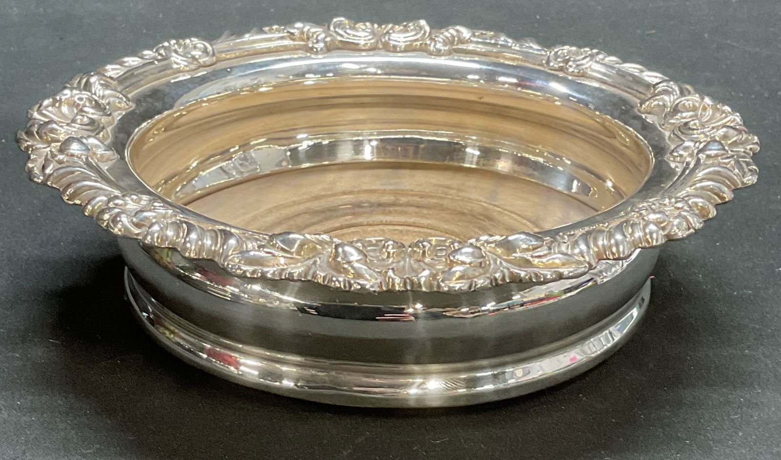 Vtg Silver Plated Wine Champagne Bottle Coaster: Vintage silver plated wine or champagne bottle coaster. Wood base and felted underside. Raised scroll rim. Measures approx 7 x 2 inches. Some scratching observed. Bottle coaster, wine bottle coaster,