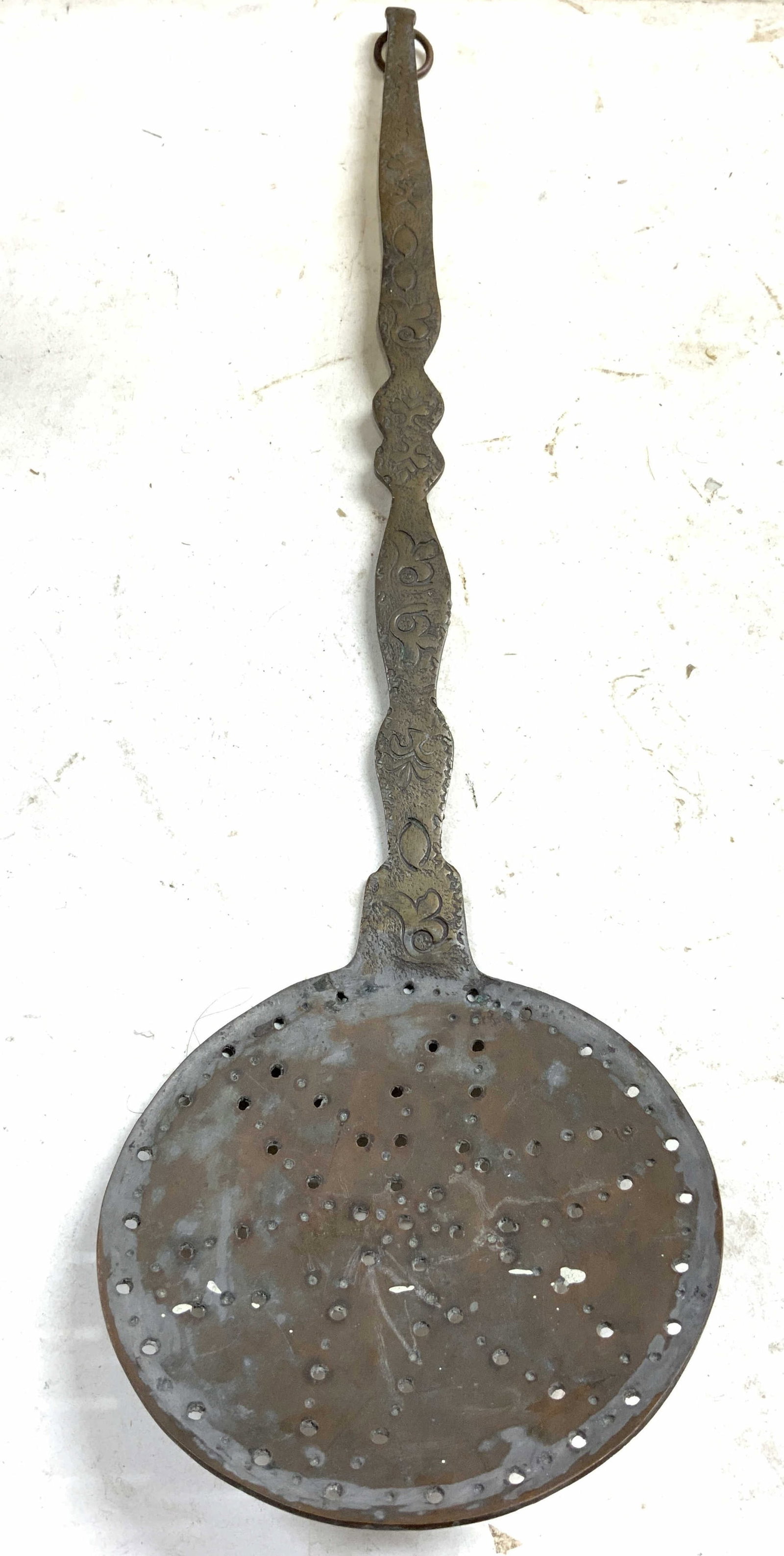Vintage Gilt Metal Skimmer Strainer W Relief 19in: Skimmer is vintage. Piece is gilt metal & has geometric relief detail on handle. End of handle has loop to hang on wall. End of piece has circular form. Piece measures approximately 19 inches long 5 i