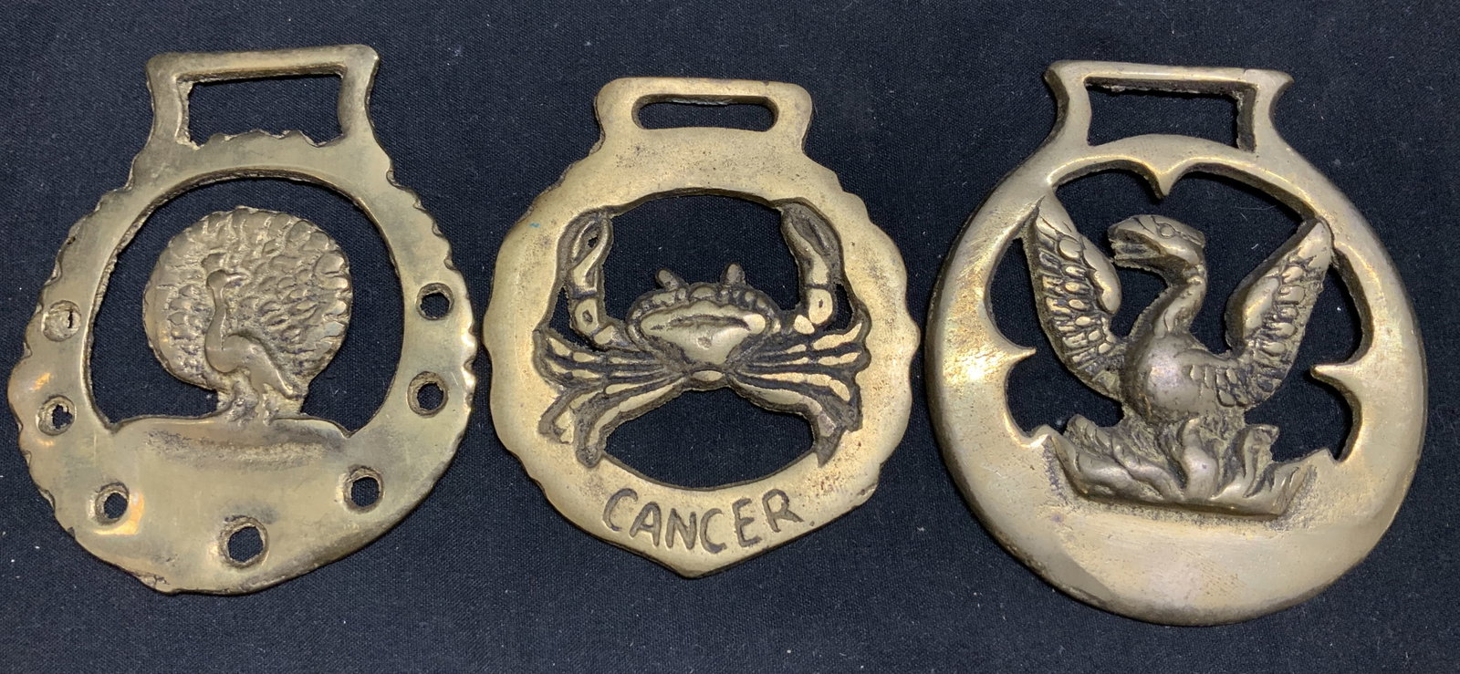 Lot 3 Zodiac, Peacock & Bird Horse Brass Medallion: Horse medallions are brass material & feature a zodiac Cancer crab, peacock & Phoenix bird design. Medallions are oval. Surface wear consistent to age, use & exposure. Measurements: length 2.5in x wid