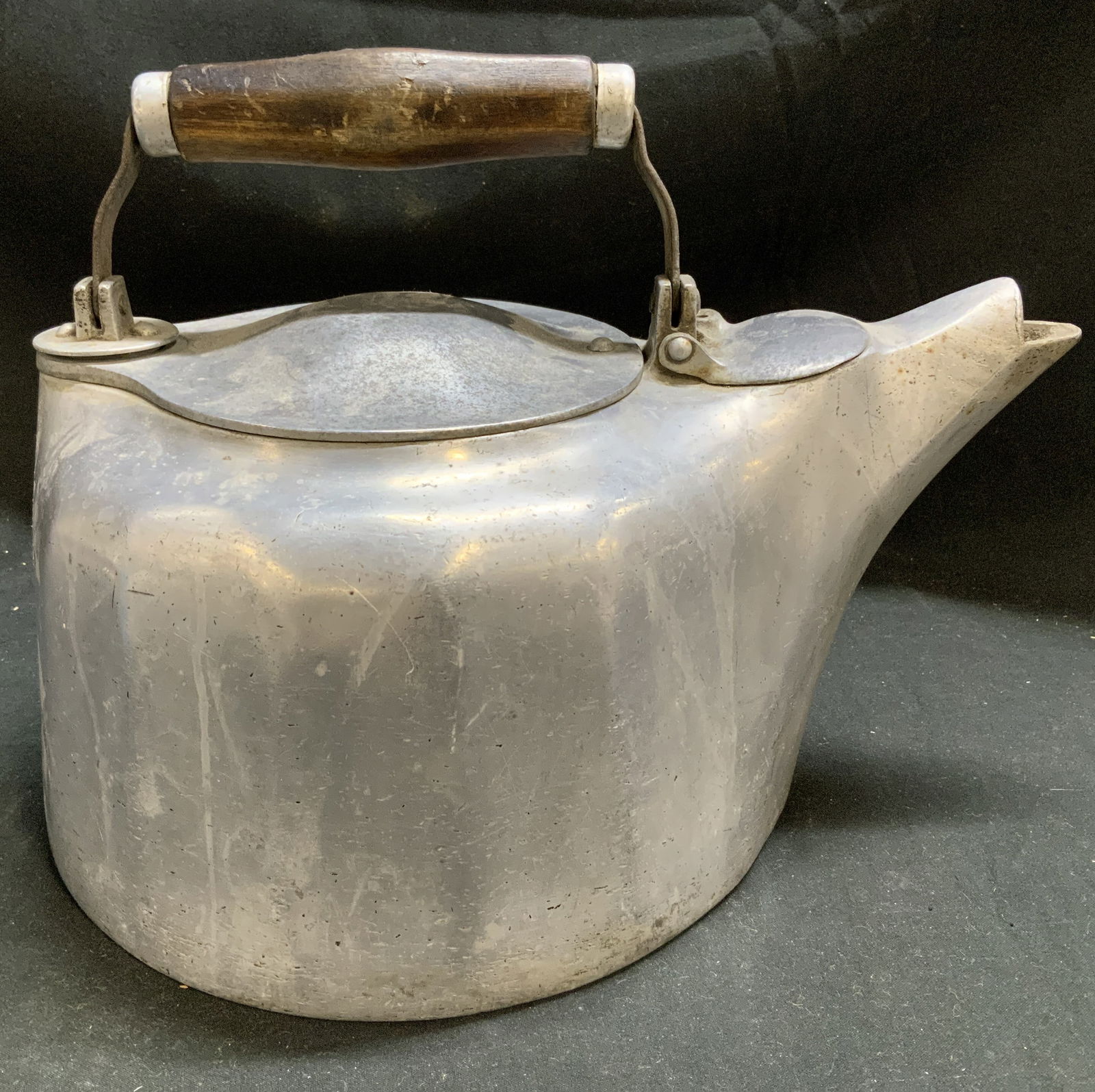 Griswold Colonial Cast Aluminum Kettle USA pat1913: Tea kettle is made of cast aluminum & features a wooden handle, a hinged lid, and a distinctive spout design. Kettle has a 4QT capacity. Reads, 4QT Colonial Design. Safety Fill. Griswold. Cast Aluminu