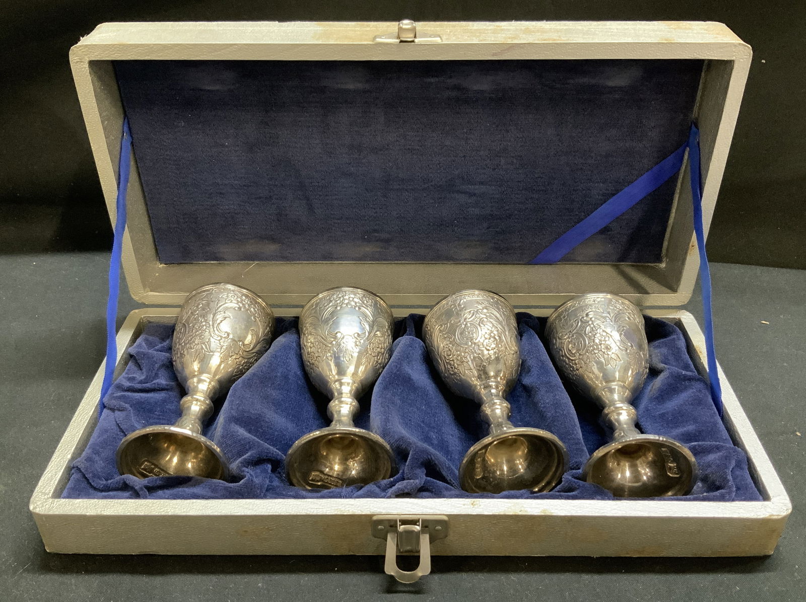 Signed Silver Plated Mini Cordial Goblets W Box: Lot includes, 4 silver plated mini cordial goblets. Goblets feature heavy embossed floral motifs & possible scrolling vines. Rim of goblets have a decorative border. Lot comes with a grey case, lined
