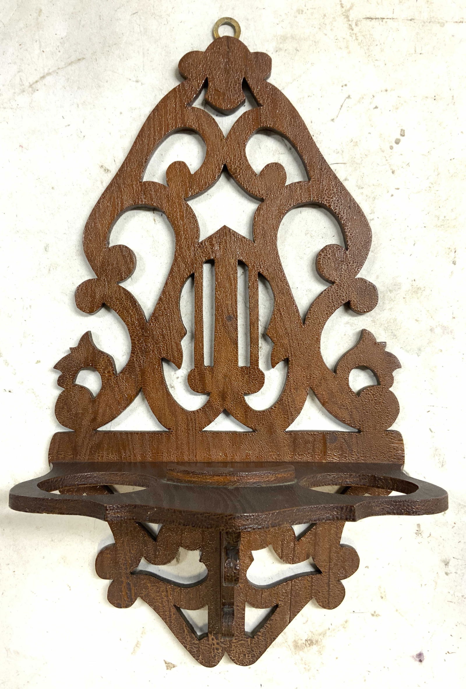 Vntg Crvd Wooden Wall Shelf Candle Holder: Wall shelf is vintage and wooden. Piece has 2 pierced circular areas for candles. Wall shelf has scrolled detail. Top of piece has metal loop to hang on wall. Measures approximately 13.5 inches tall 7