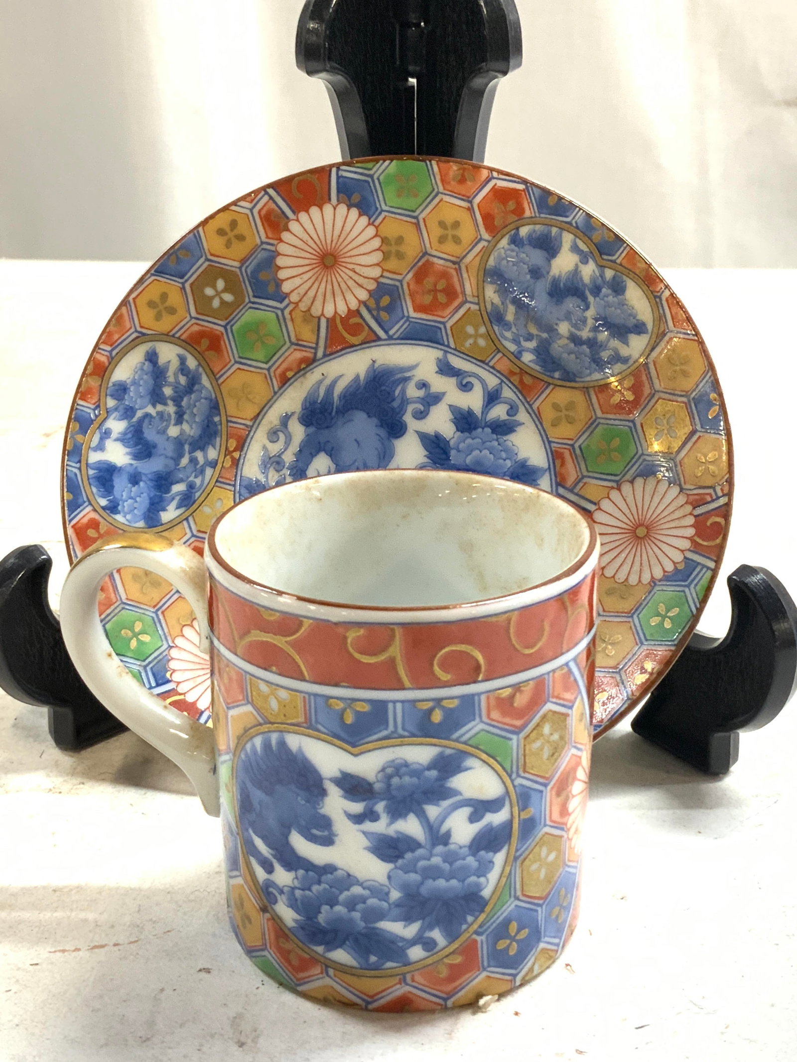 Signed OMC Japan Vintage Set Asian Teacup & Saucer: Undersides are signed in blue toned Asian characters. Yellow toned tags read OMC JAPAN. Lot includes 1 teacup and 1 saucer. Set is vintage. Some elements possibly hand painted. Saucer measures approxi