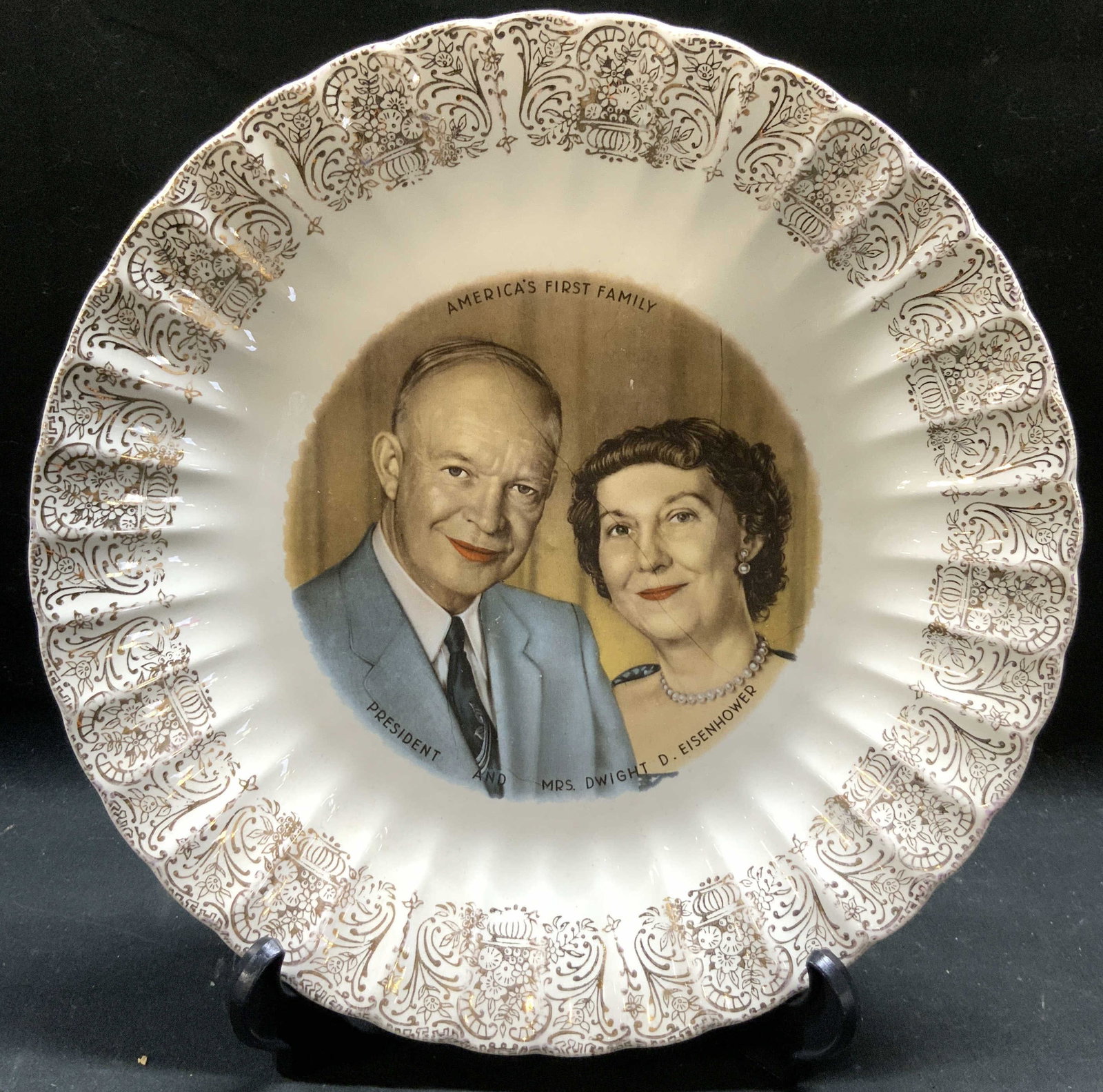 Vtg Fluted Porc Americas 1st Family Plate: Plate is vintage and porcelain. Piece has intricate gilt detail around edges. Center of plate has depiction of Americas first Family President & MRS DWIGHT D EISENHOWER. Piece measures approximately 9