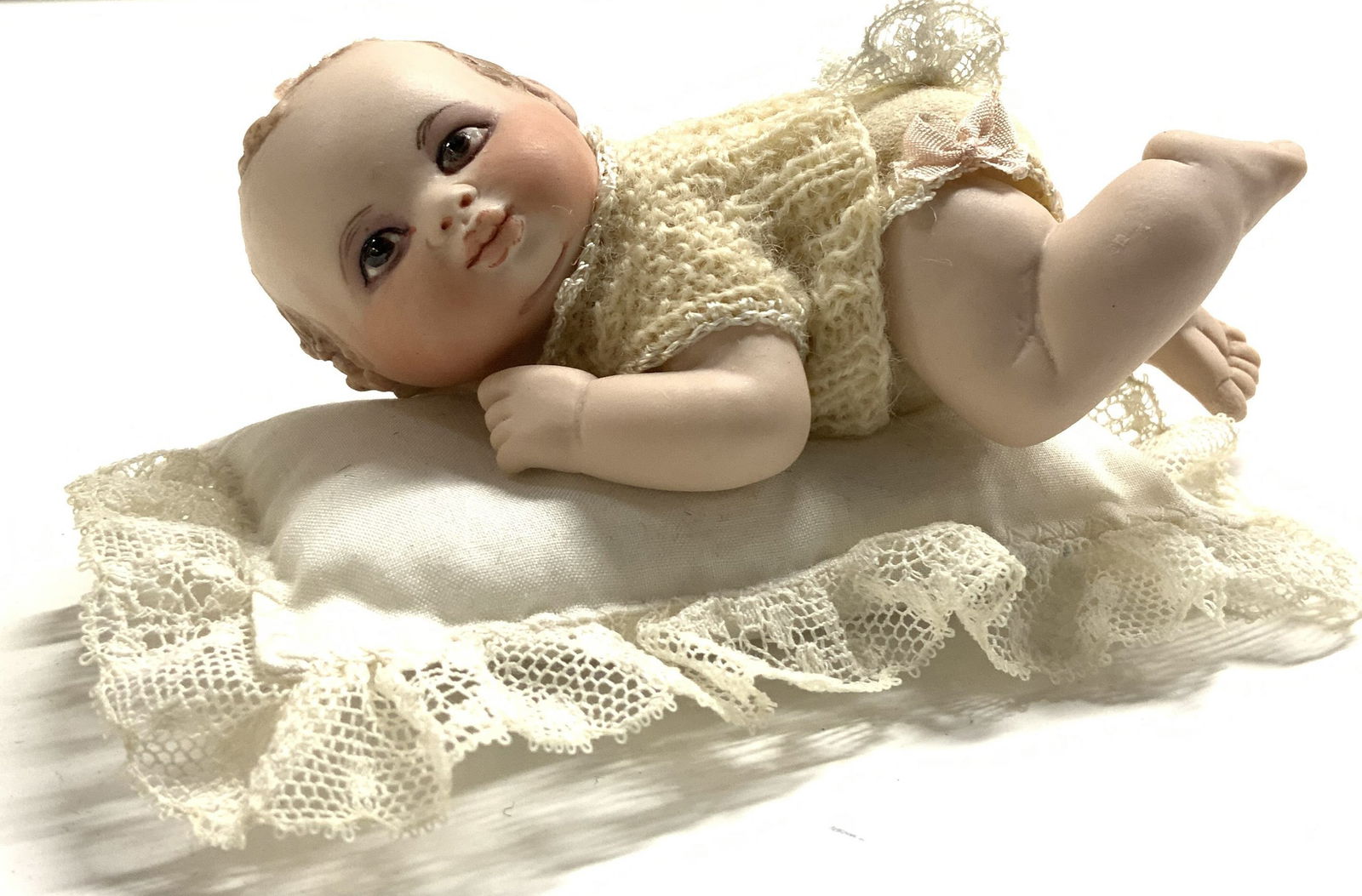 Vntg Bisque Crawling Baby Doll Fig w Pillow: Figure depicts a baby crawling. Lot also includes pillow. Piece appears to be bisque. Some elements appear to be hand painted. Baby is wearing cream toned clothing. Measures approx 4.25 inches long 2.