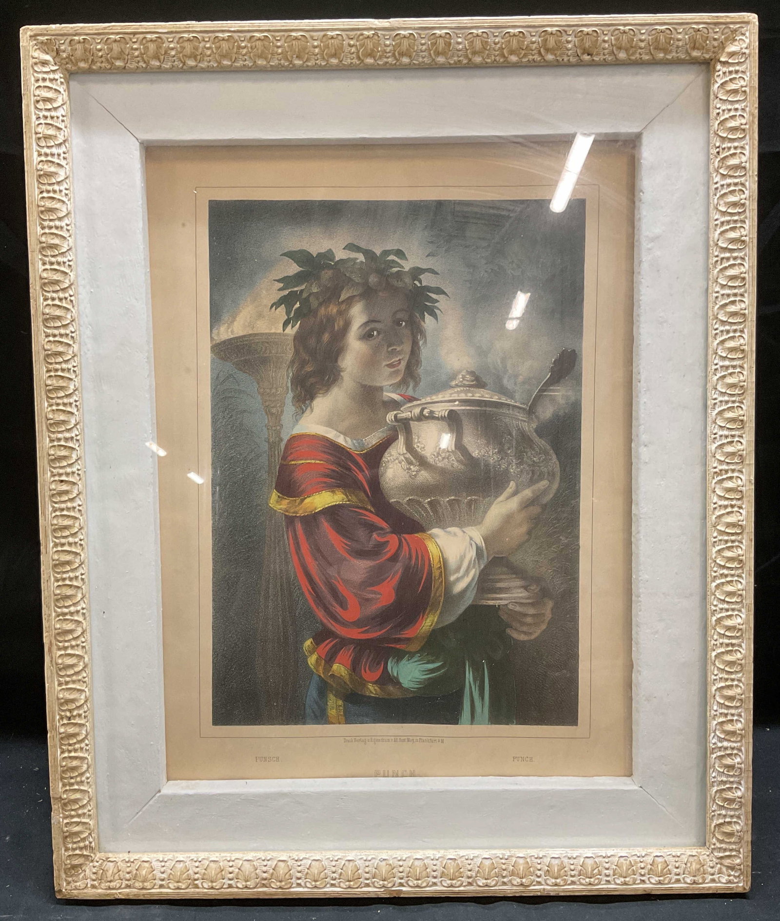 Antique Cruck Verlag Punch German Color Lithograph: Framed antique color lithograph. Punch. Classical scene with woman holding bowl of punch. Published and printed by Druck Verlag in Germany, Gust May. White wood frame with molded scroll border. Not ex