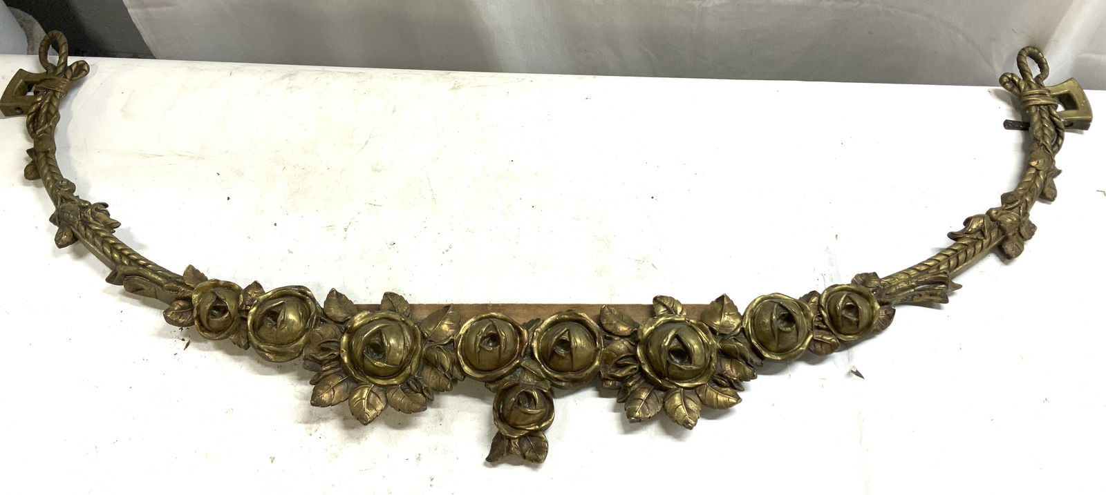 Vntg Bronze Floral Garland Wall Swag Ornament 46in: Vntg Bronze Floral Garland Wall Swag Ornament Ornament is bronze material & features a curved & intricate floral design, specifically roses and leaves. Backside is attached to a piece of thin wood. Su