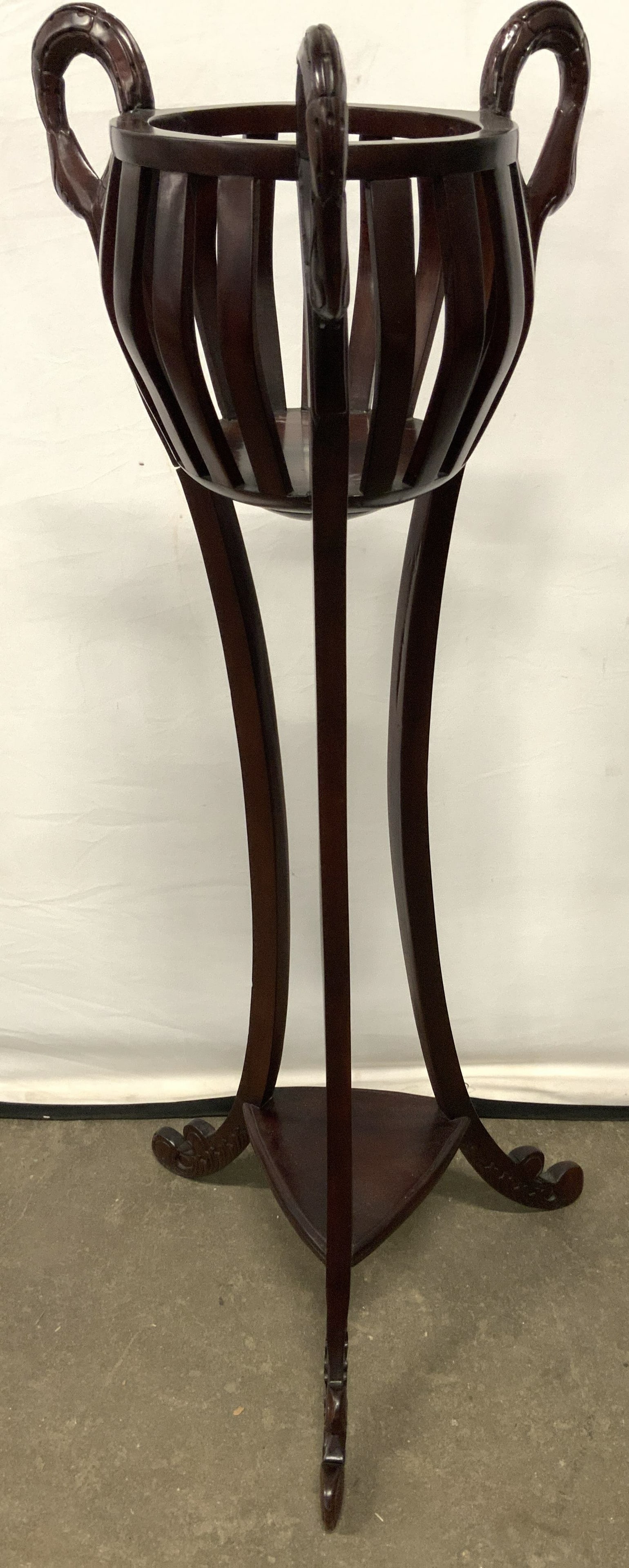 Vtg Swan Head Carved Wood Regency Plant Stnd 50in: Plant stand is brown toned and wooden. Piece is regency style with carved wooden swan head structures. Piece has center area to hold plants. Base has 3 carved wooden legs and feet with board stretcher