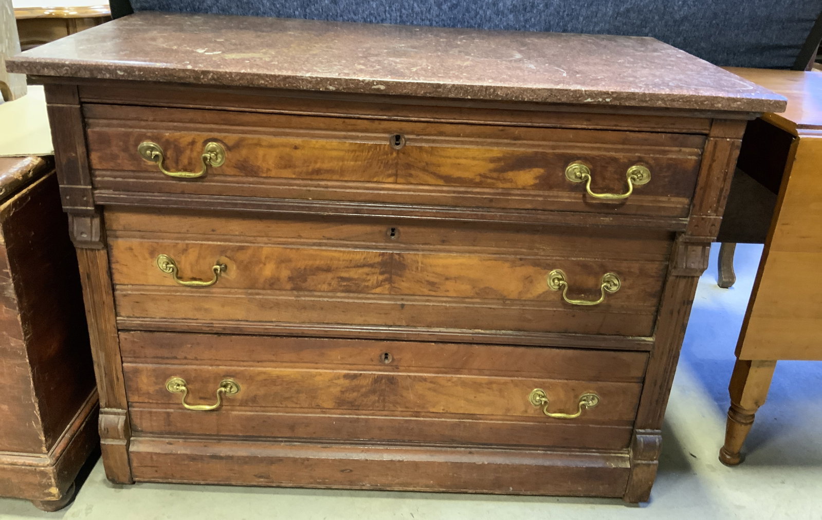 Vintage 3 Drawer Wooden Marble Top Dresser: Dresser is vintage and wooden. Piece has maroon toned marble top. Dresser has 3 drawers, each with gilt metal handles and dovetailing. Dresser is brown toned. Dresser measures approximately 41 inches 