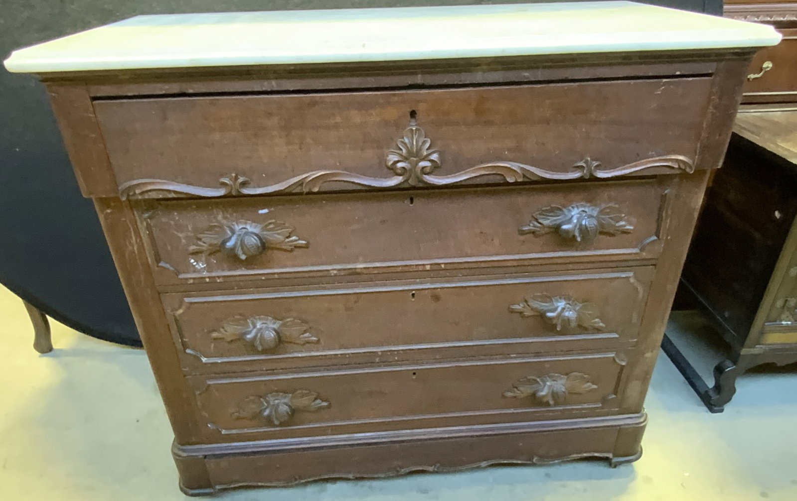 Vtg 4 Drawer Wood Marble Top Dresser W Caster: Dresser is vintage and wooden. Piece has white toned marble top & 4 drawers each with dovetailing & carved fruit and leaf handles. Dresser sits on 4 casters. Measures approx 44 inches tall 39 inches w