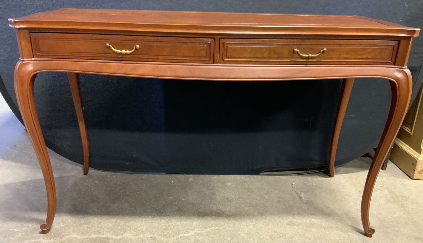 Vintage Wooden 2 Drawer Console Table: Console table is vintage. Piece is tan toned and wooden. Console table has 2 drawers each with gilt metal handles and dovetailing. Table has slightly curved legs. Measures approximately 49 inches long